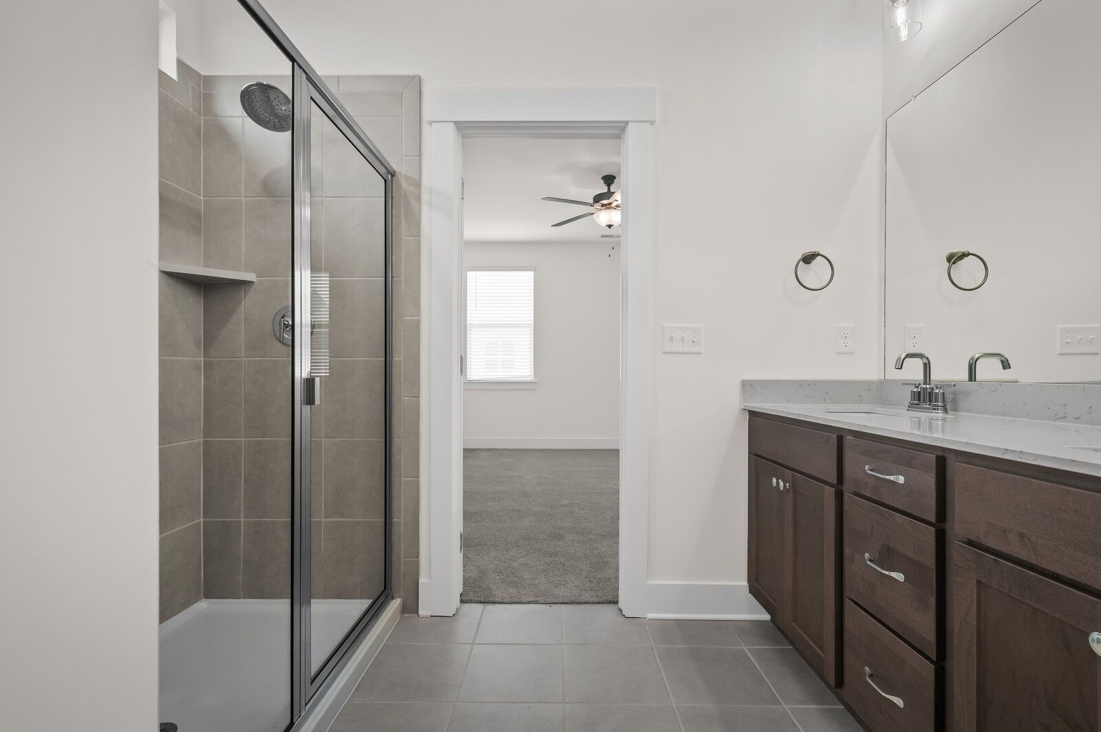 Modern bathroom with tiled walk-in shower and dark wood vanity in The Ash A floor plan at Woods Crossing, Gallatin, TN.