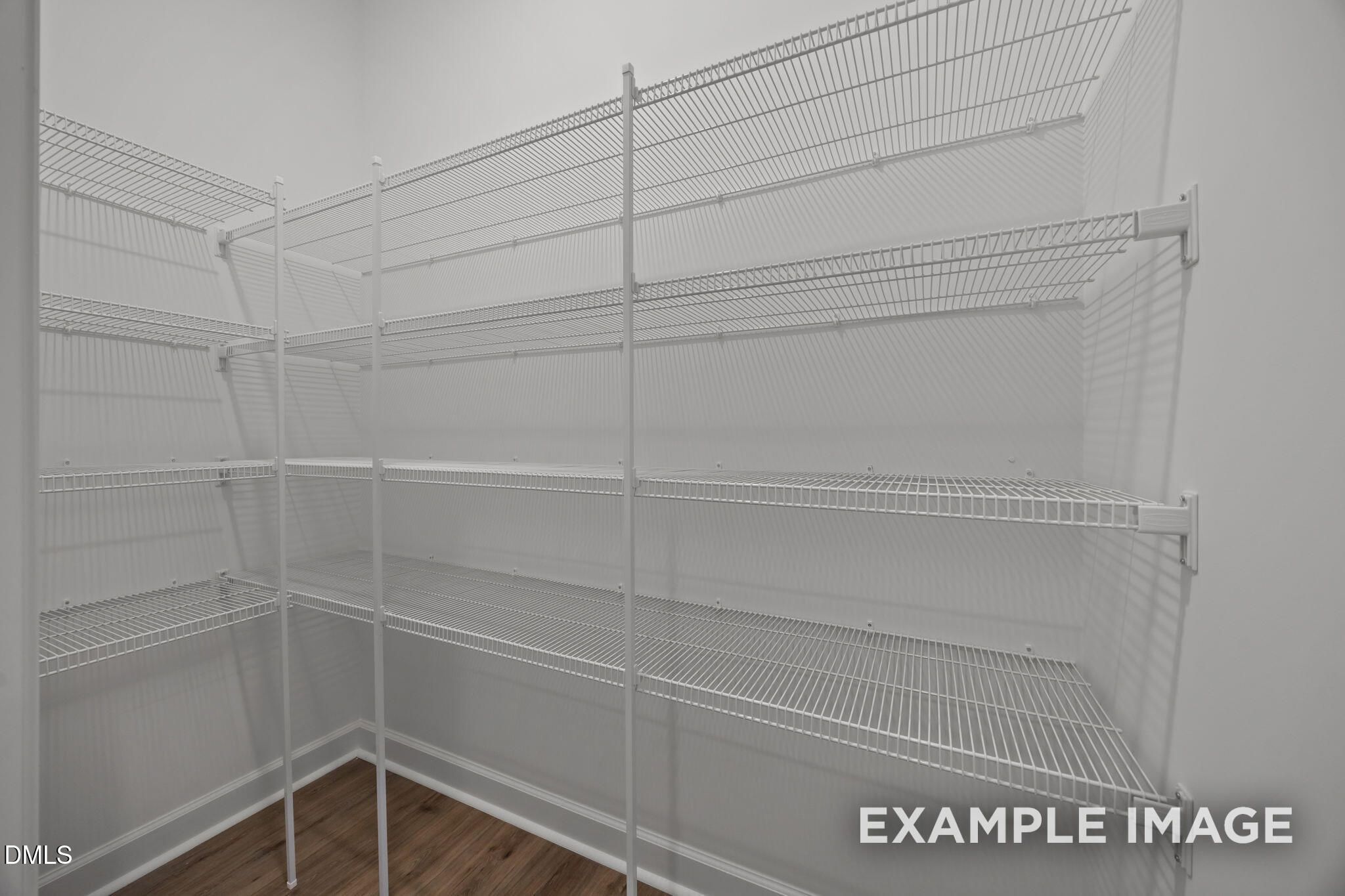 Walk-in closet with white wire shelving and wood-look flooring in Davidson Homes The Beech at Wendell Ridge, North Carolina