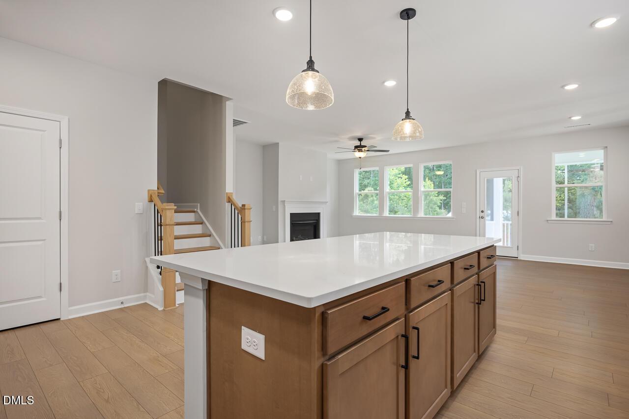 Open-concept kitchen with large island and pendant lighting in The Ashport L floor plan at Sage on North Main, Wake Forest.