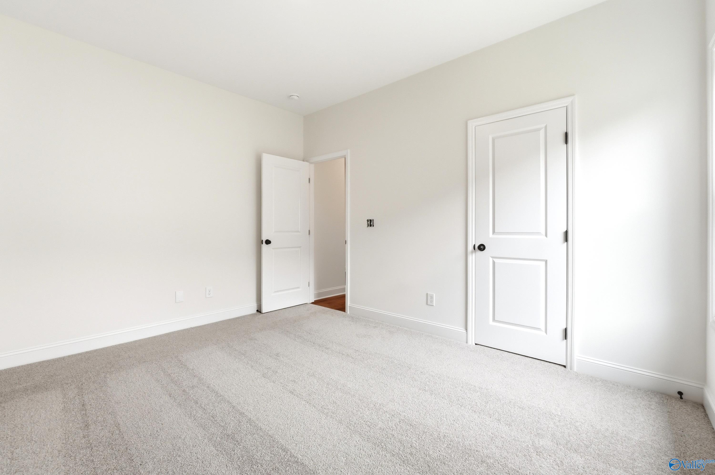 Bright, carpeted spare bedroom with white walls and doors in The Daphne C floor plan by Davidson Homes in Ivy Hills, Toney.