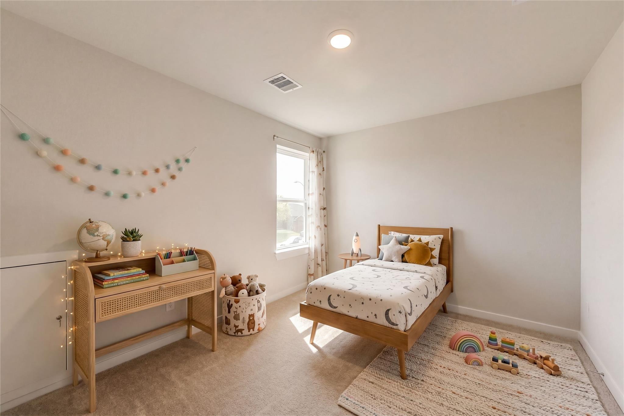 Cozy children's bedroom featuring wooden bed with starry bedding, rattan desk, stuffed animals, and wooden toys in The Brazos E home, Dayton, Texas