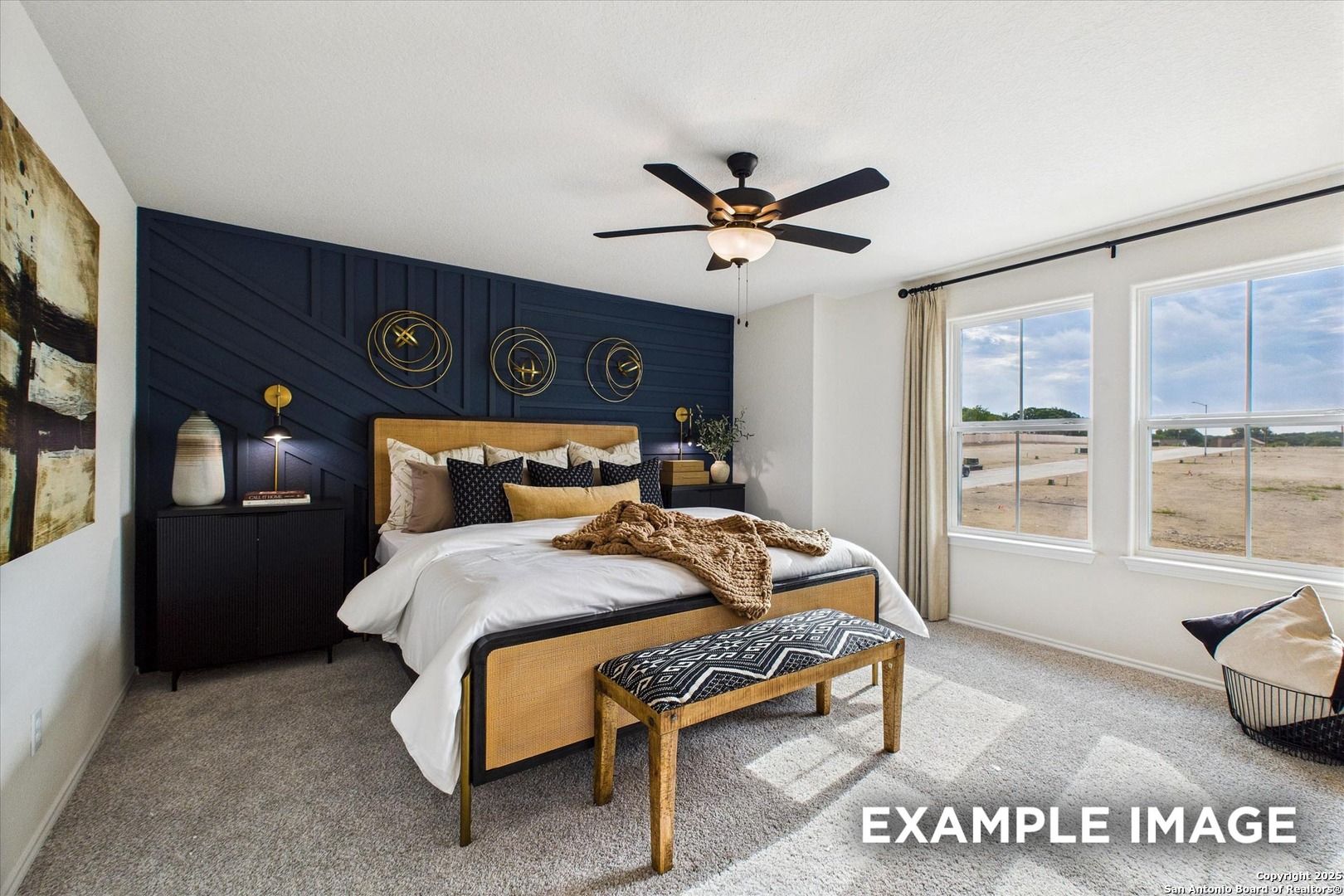 Elegant master bedroom with navy accent wall, plush king bed, gold decor, and large windows in Davidson Homes The Florence C, San Antonio