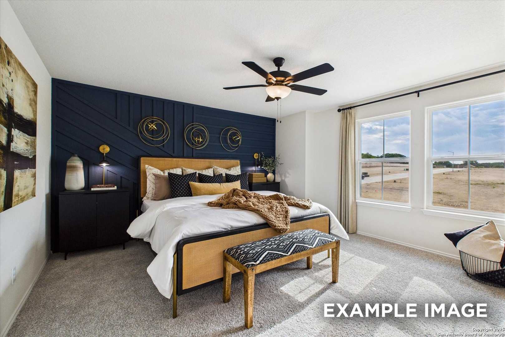 Elegant master bedroom with navy accent wall, plush king bed, gold decor, and large windows in Davidson Homes The Florence C, San Antonio