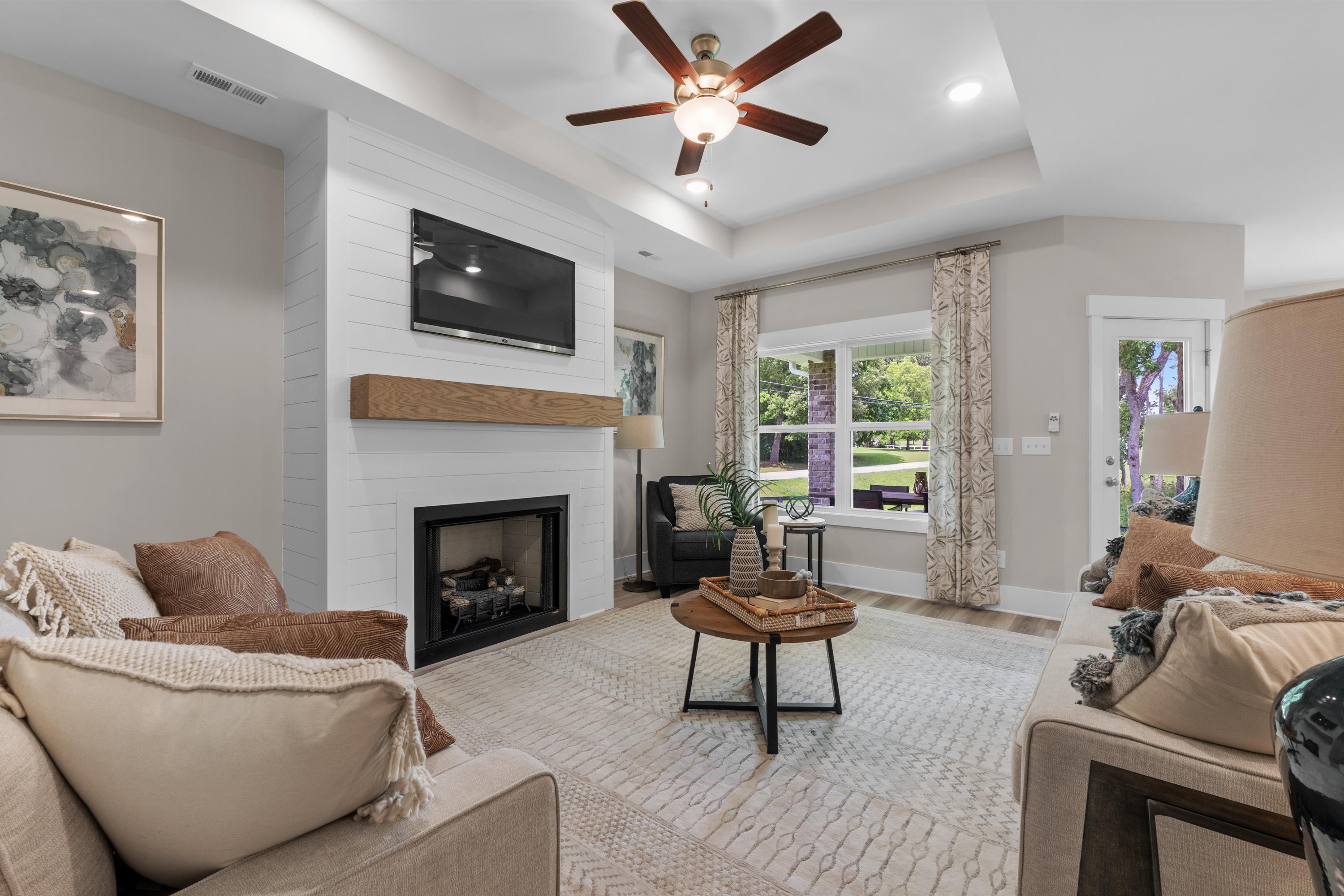 Cozy living room at The Highlands in Arab Alabama with shiplap fireplace, ceiling fan, large windows and plush seating