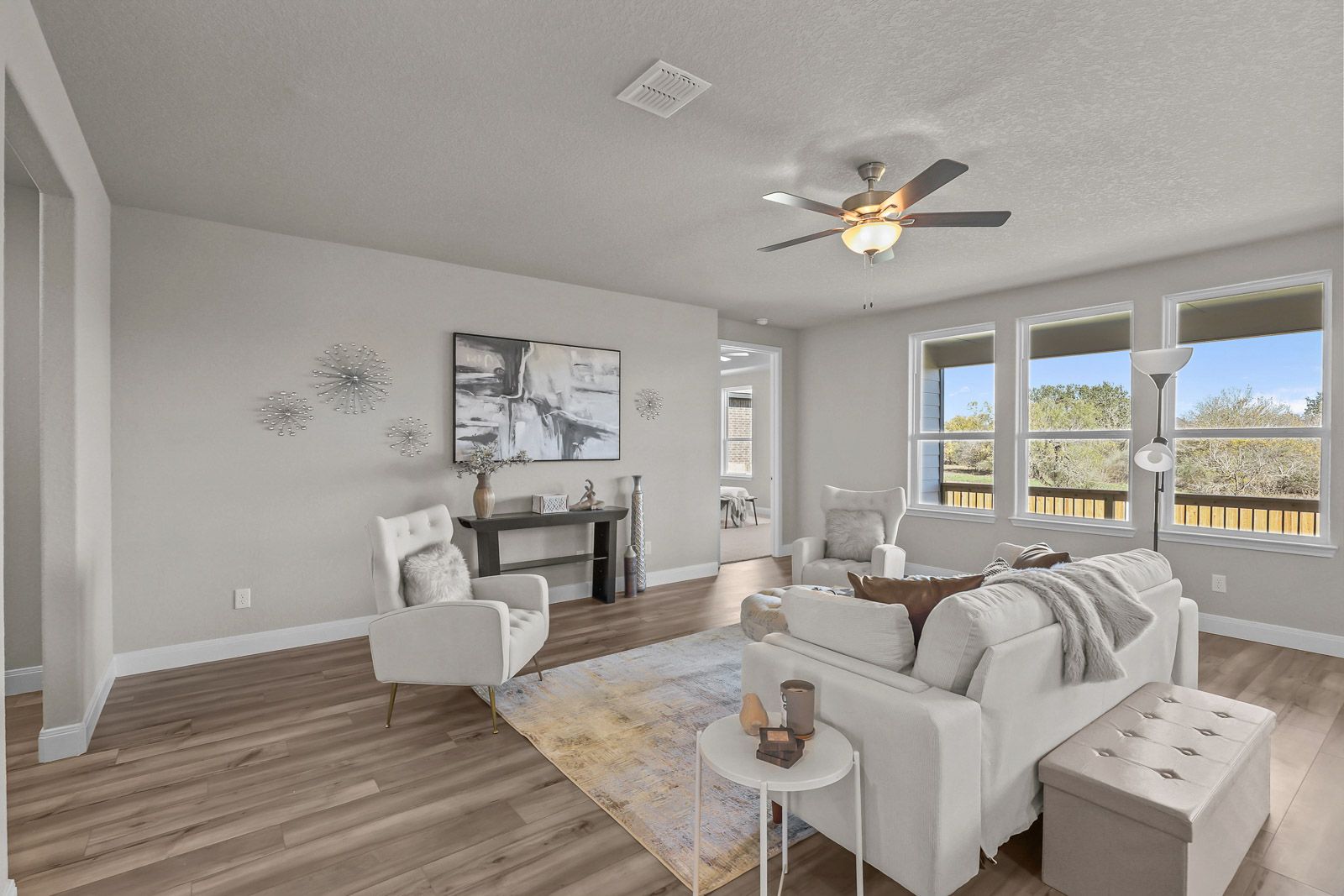 Spacious, light-filled living area in The Jennings G featuring modern decor, comfortable seating, and wood-style flooring.