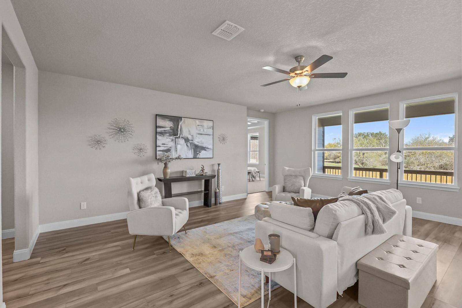 Spacious, light-filled living area in The Jennings G featuring modern decor, comfortable seating, and wood-style flooring.
