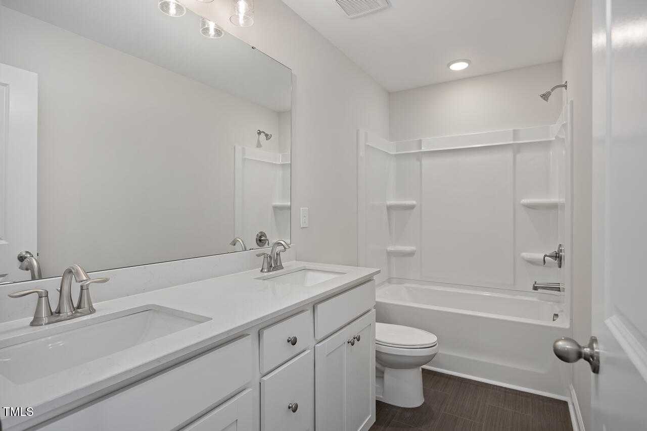 Modern bathroom featuring double vanity, soaking tub, and walk-in shower in Davidson Homes The Graham, Fuquay-Varina, NC