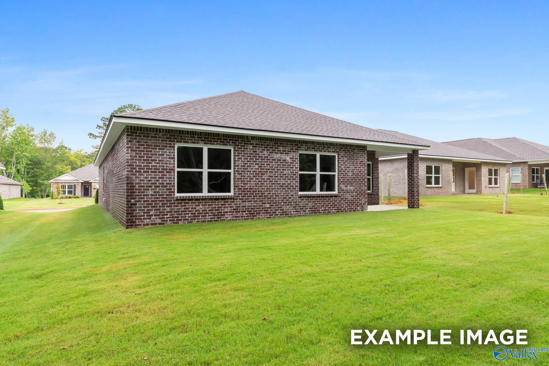 Brick single-story home exterior with large windows and 2-car garage in Blue Spring, Huntsville, Alabama by Davidson Homes The Daphne C