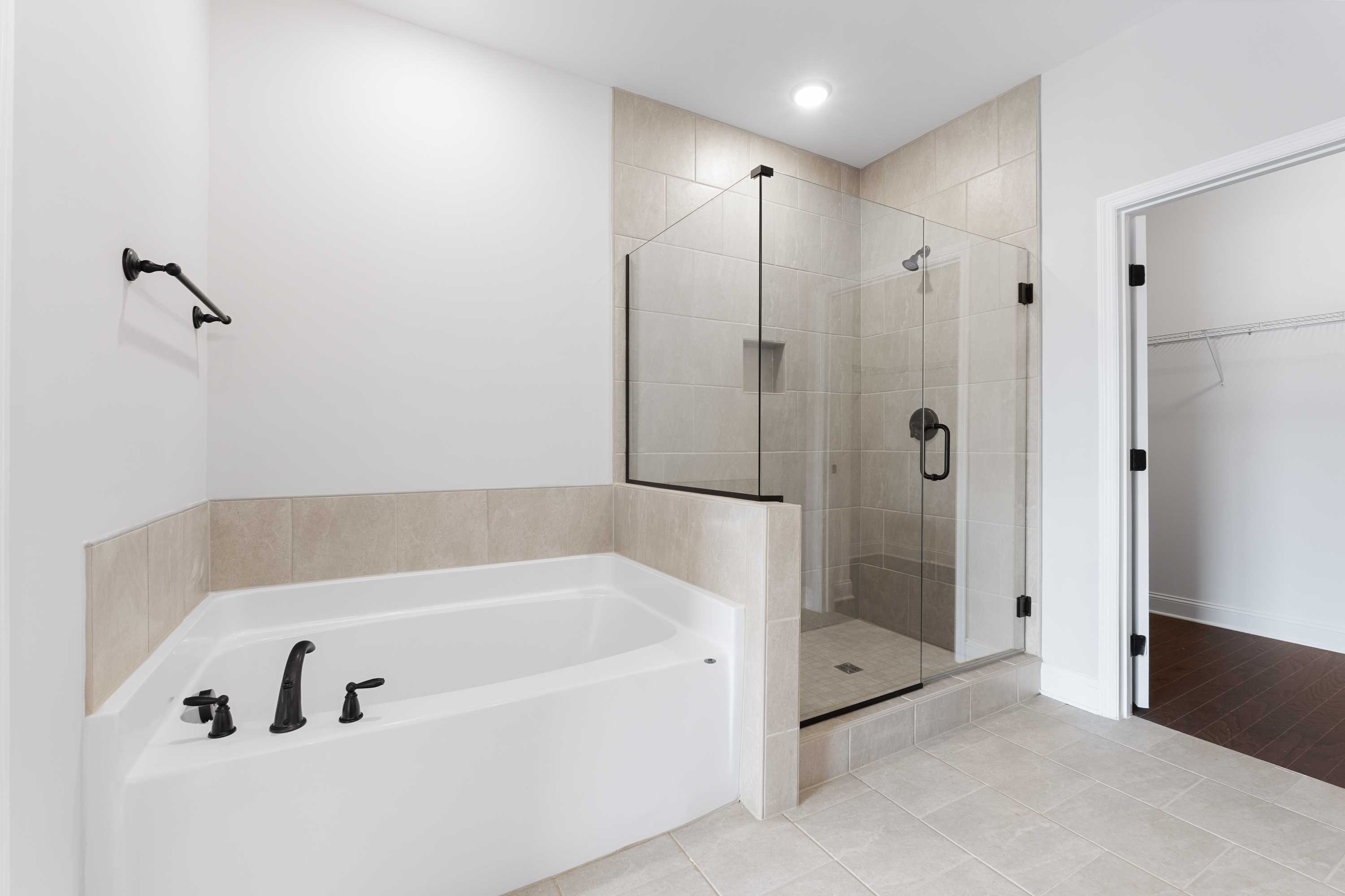 Modern master bathroom in The Copeland by Davidson Homes featuring soaking tub and frameless glass shower