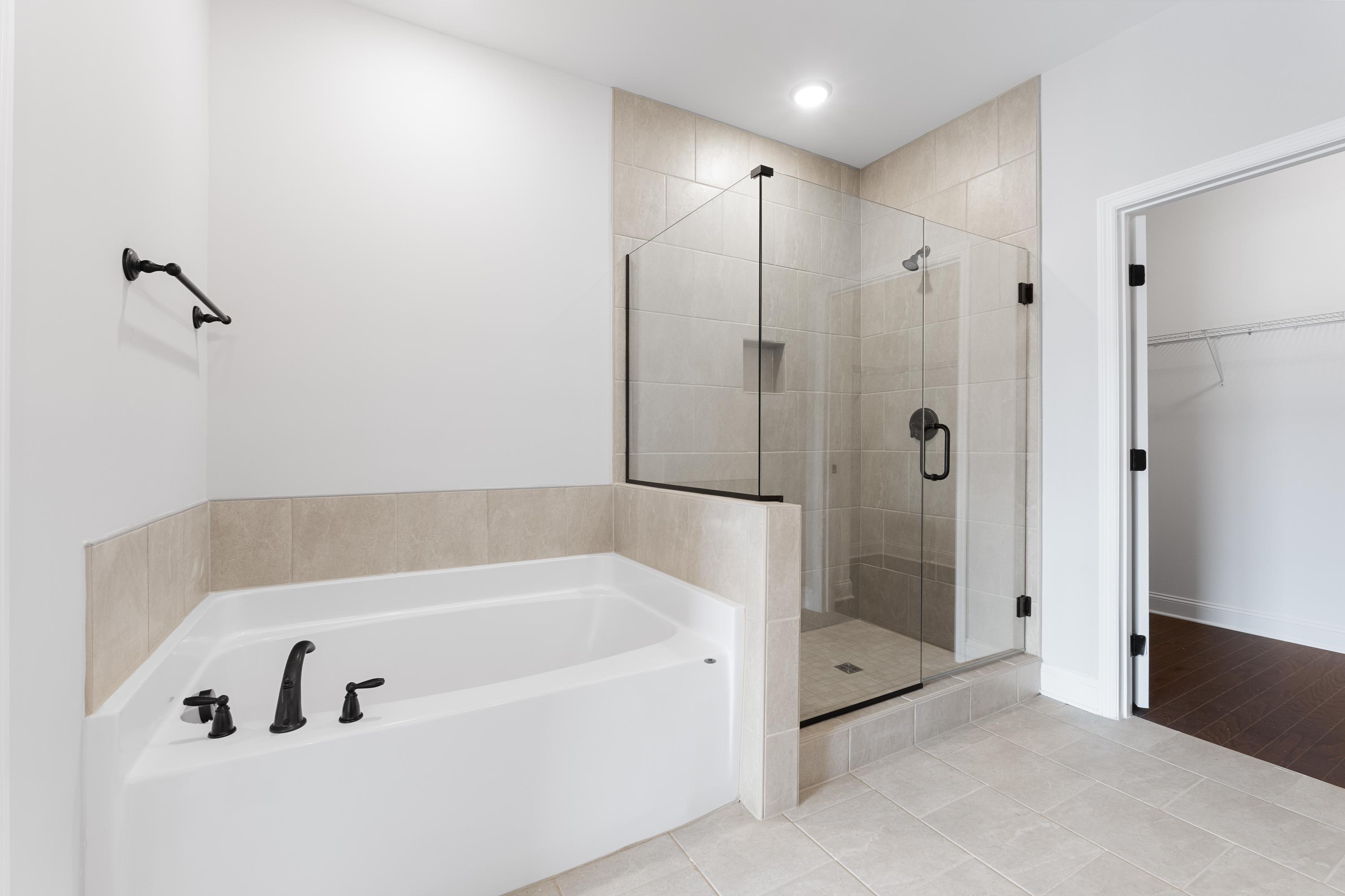 Modern master bathroom in The Copeland by Davidson Homes featuring soaking tub and frameless glass shower