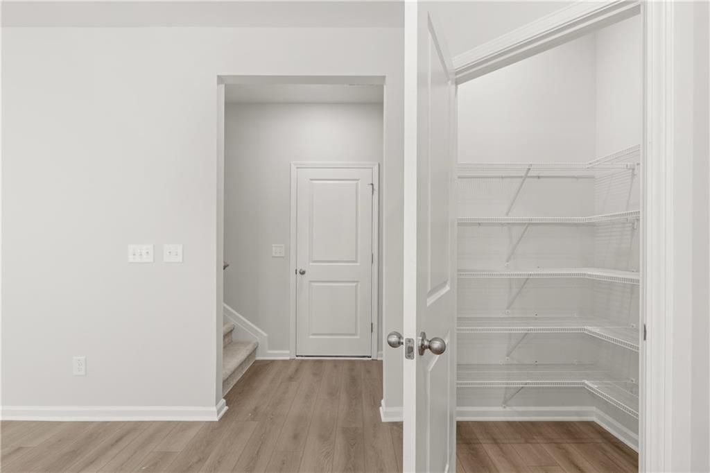 Walk-in pantry with white wire shelving in The Burton A floor plan at The Bluffs, Canton, Georgia.