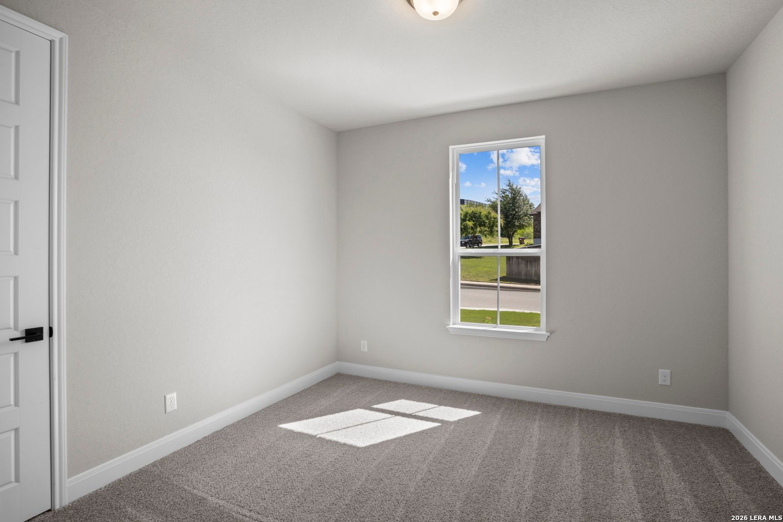 Bright bedroom with neutral paint and plush carpeting in The Jennings G floor plan at Ladera, San Antonio, Texas.