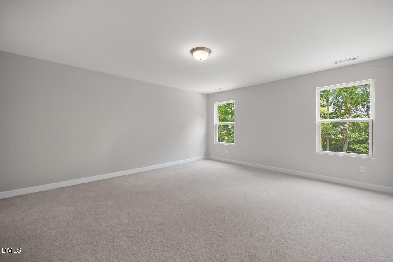 Spacious, carpeted bedroom with neutral walls in The Hickory II B floor plan at Wellers Knoll in Lillington, NC.