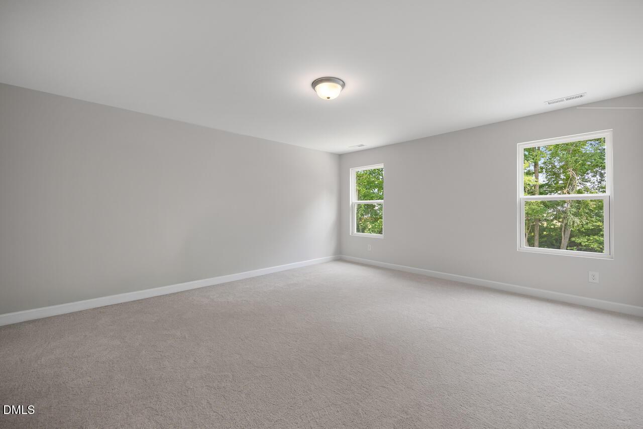 Spacious, carpeted bedroom with neutral walls in The Hickory II B floor plan at Wellers Knoll in Lillington, NC.