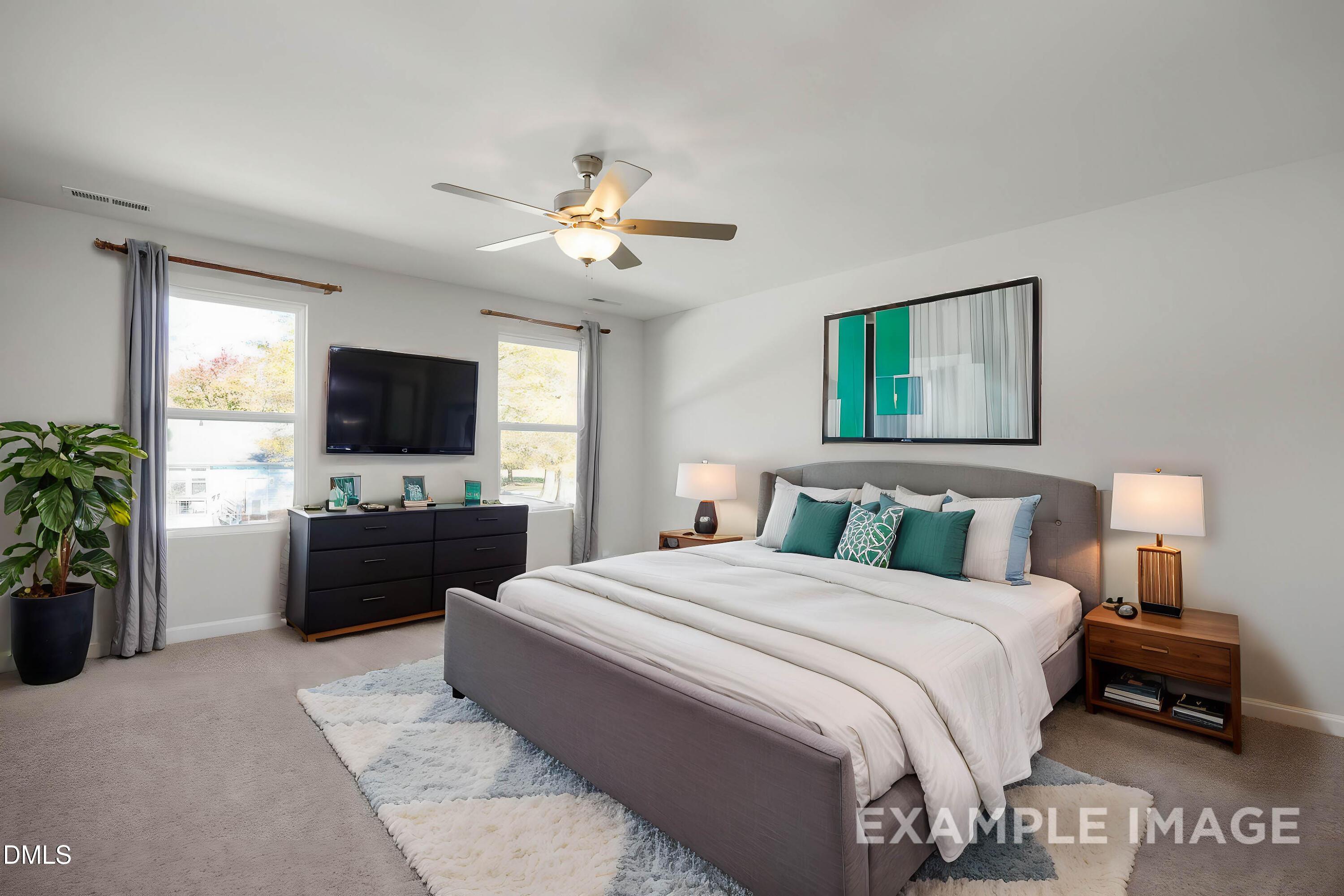 Elegant master bedroom with king bed, ceiling fan, wall TV, and large window in Davidson Homes Adalynn A, Lillington, NC