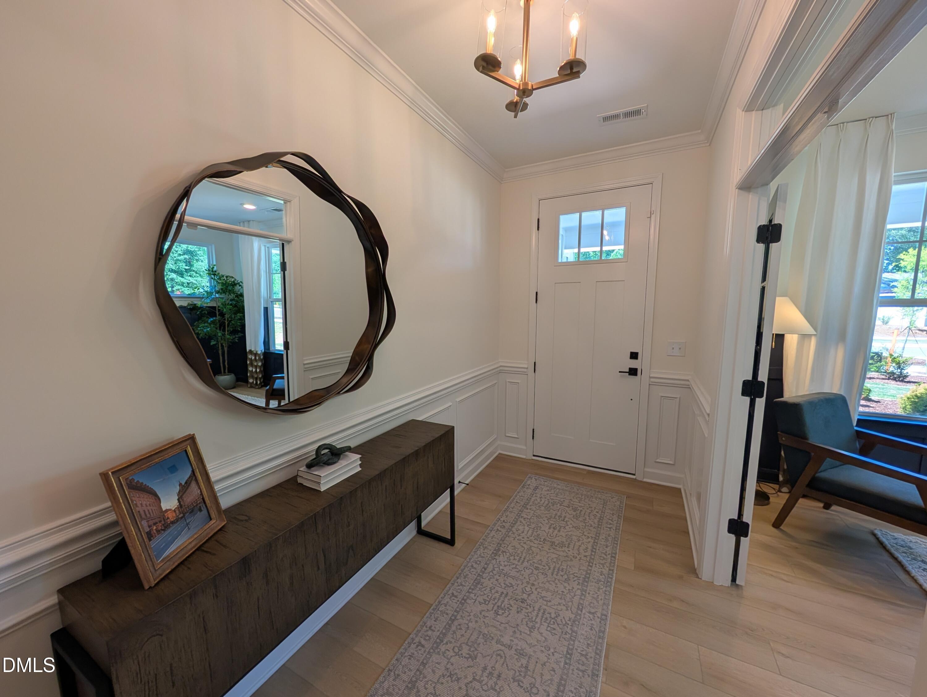 Bright foyer entry with modern mirror and console table in The Aspen B floor plan by Davidson Homes in Wendell, NC.