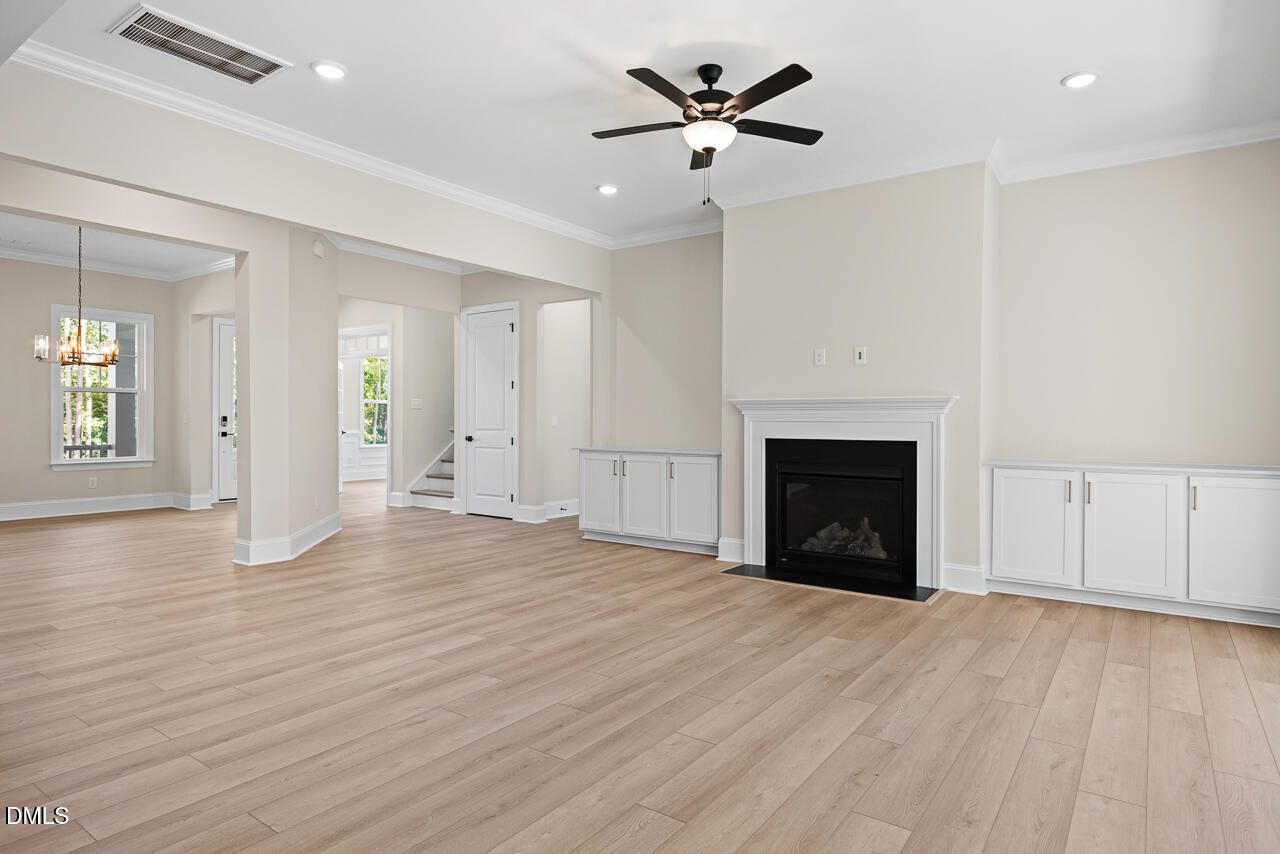 Open-concept living room with fireplace, ceiling fan, and hardwood floors in Davidson Homes Crawford D plan, Wake Forest, NC