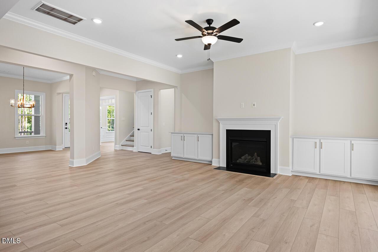 Open-concept living room with fireplace, ceiling fan, and hardwood floors in Davidson Homes Crawford D plan, Wake Forest, NC
