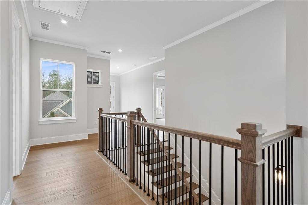 Elegant dark wood staircase with balusters in light gray upstairs hallway of 4-bedroom Davidson Homes The Seaside B, Woodstock, Georgia