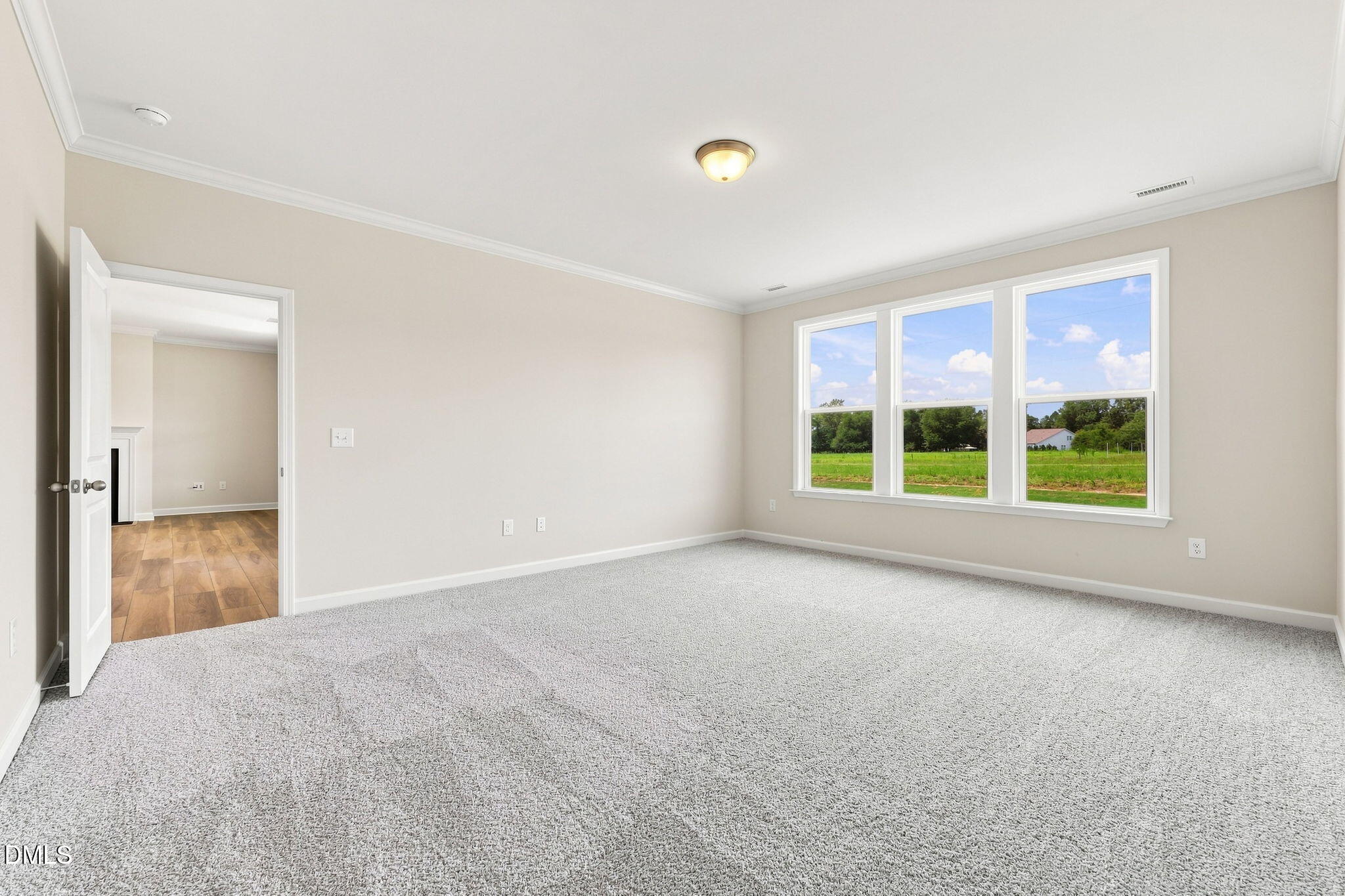 Bright, carpeted bedroom with large windows and country views in The Magnolia B floor plan at Retreat at North Main.