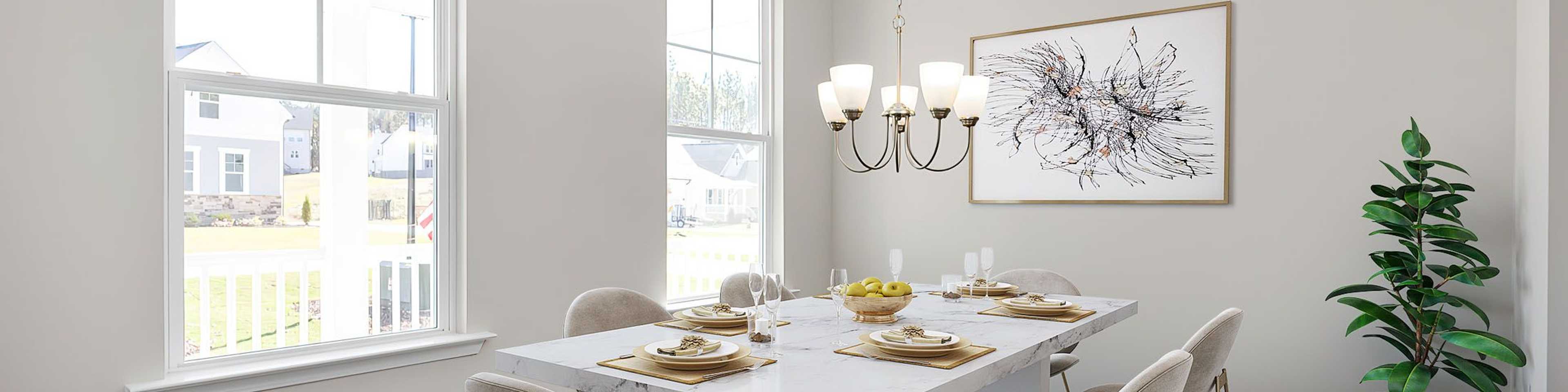 Modern dining room in new Mebane home with white table, beige chairs, chandelier, abstract art, and porch view