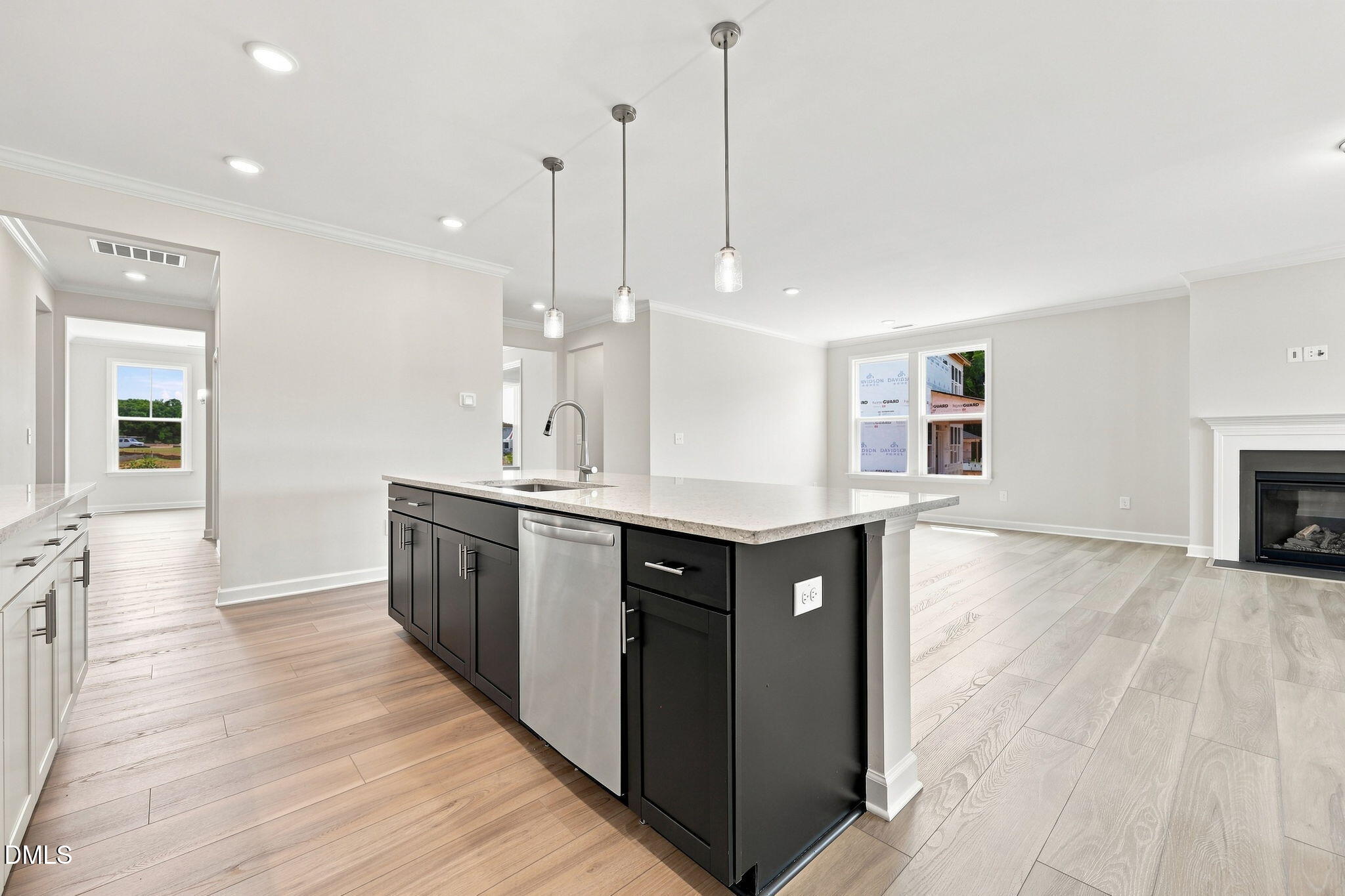 Open-concept kitchen with dark island and quartz countertops in The Magnolia B floor plan at Retreat at North Main, Lillington