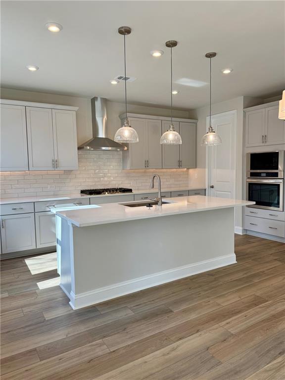 Modern white kitchen with quartz island, stainless steel appliances, subway tile backsplash in The Danbury C, Buford, Georgia