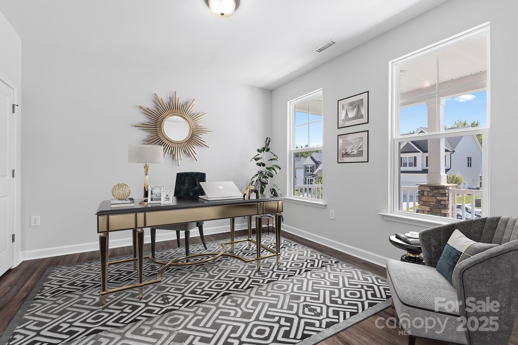 Elegant home office with brass desk, sunburst mirror, armchair, and neighborhood view in Davidson Homes The Hemlock A, Belmont, NC