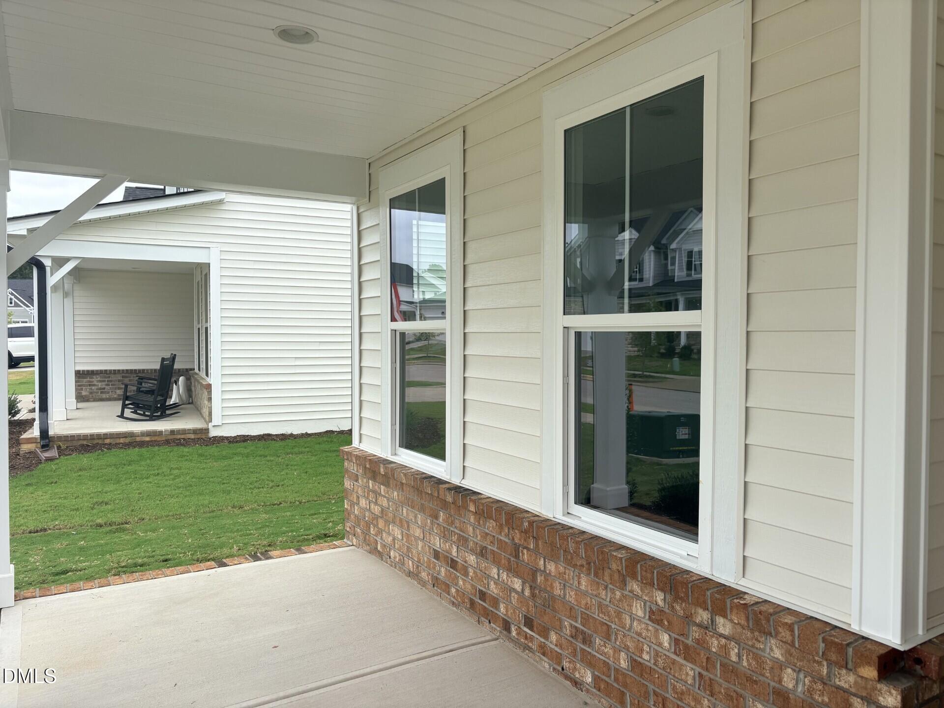 Covered front porch with brick accents and white siding on Davidson Homes' The Hickory II B in Woodland Crossing, Zebulon, NC