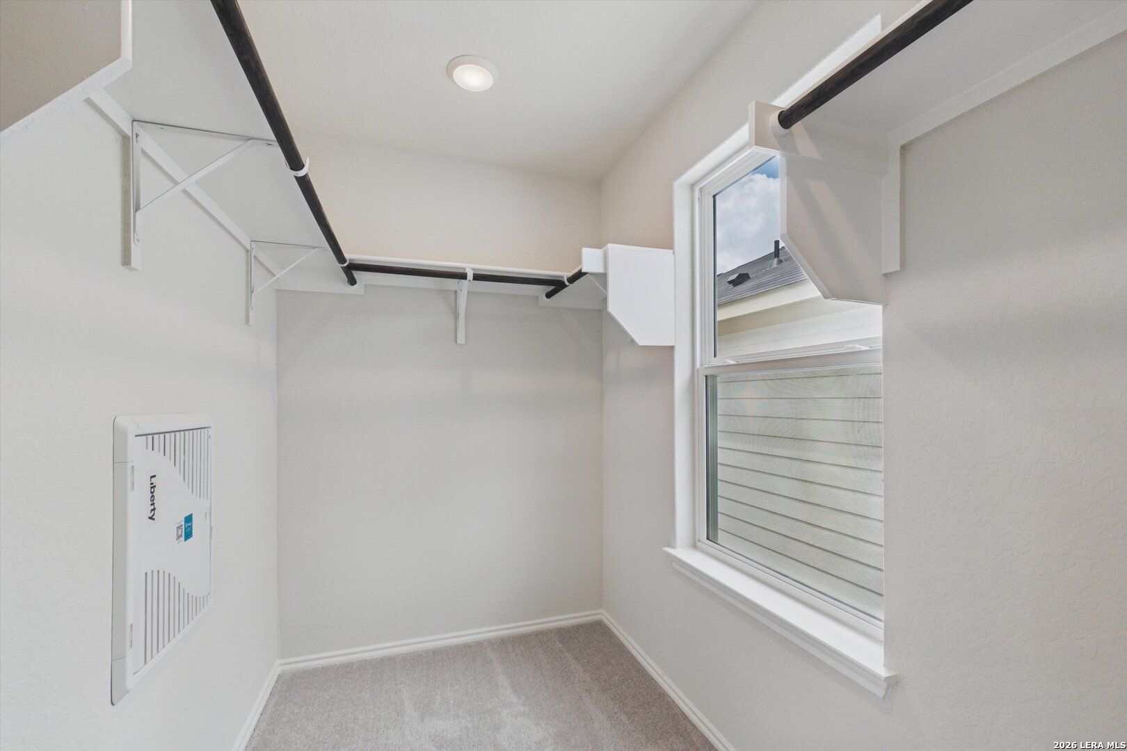 Walk-in closet with white shelving and window in The Charlotte B floor plan at Meadows at Oak Creek, San Antonio, Texas.