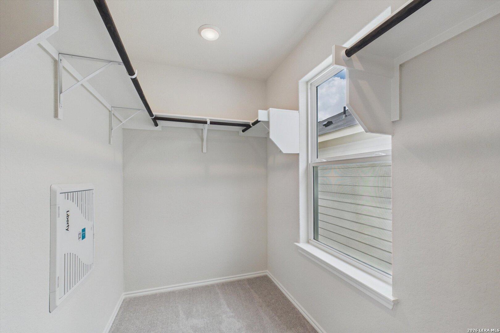 Walk-in closet with white shelving and window in The Charlotte B floor plan at Meadows at Oak Creek, San Antonio, Texas.