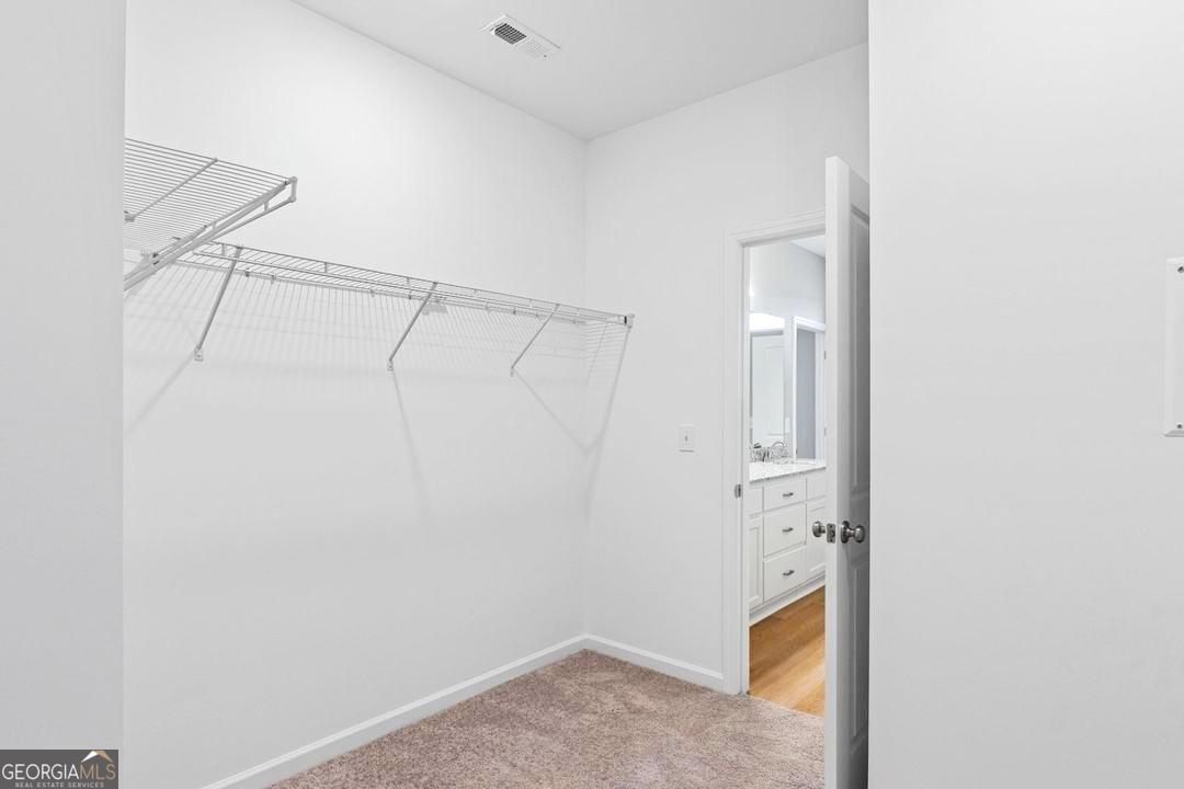 Walk-in closet with wire shelving in The Stella floor plan at Ivy Glen in Perry, Georgia.