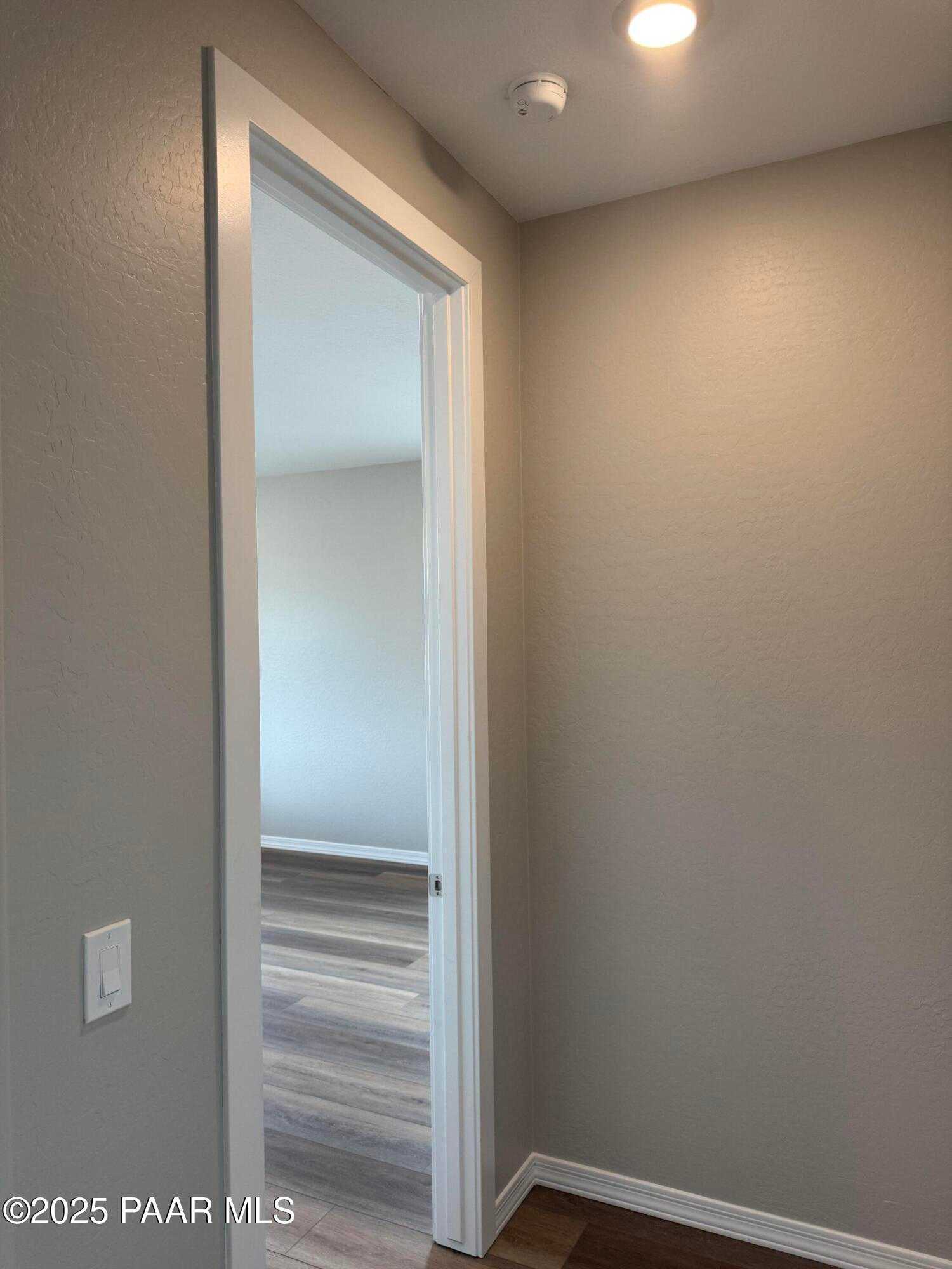 Open doorway to interior room with beige walls, hardwood floors, and modern trim in 3-bedroom Davidson Homes The Monarch A, Prescott Arizona
