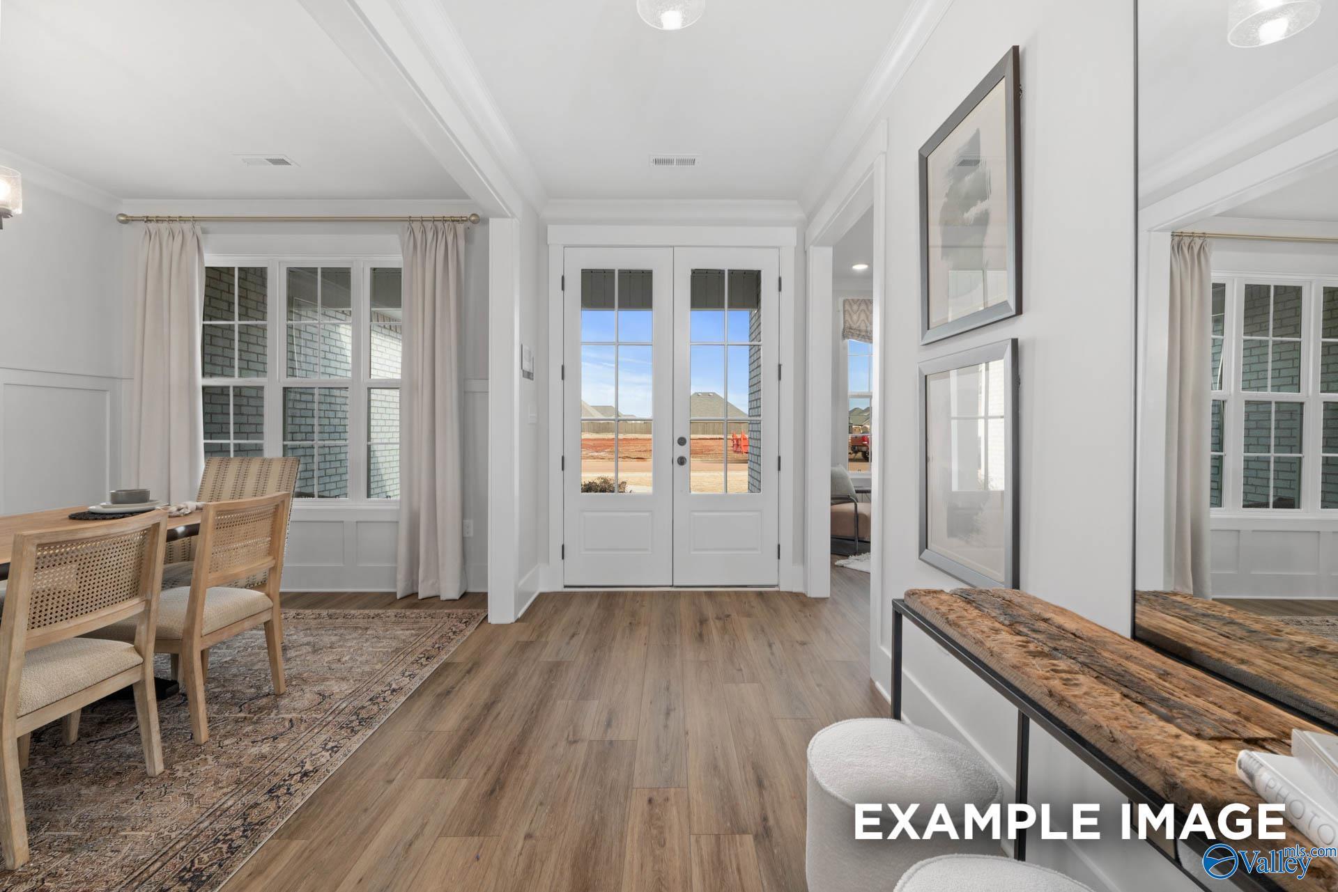 Elegant foyer with open French doors to backyard patio, luxury LVP flooring, and dining nook in Davidson Homes The Finleigh, Decatur, AL