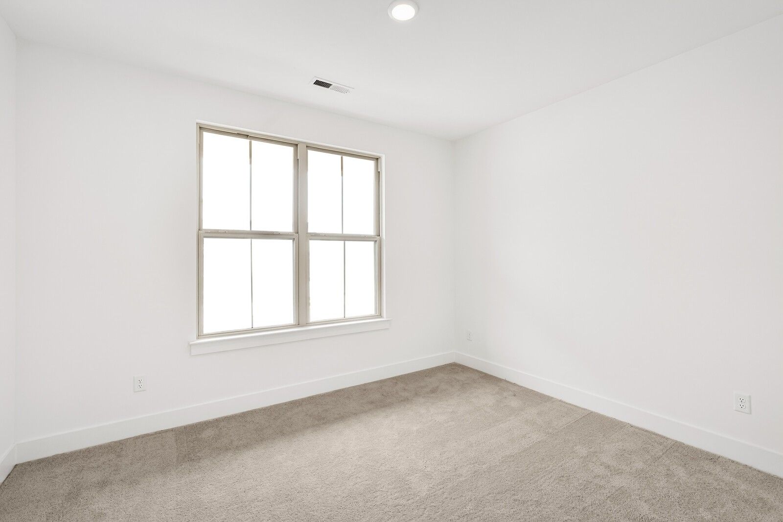 Bright empty bedroom with large window, white walls, and beige carpet in Davidson Homes Ridgeport C, Gallatin, TN