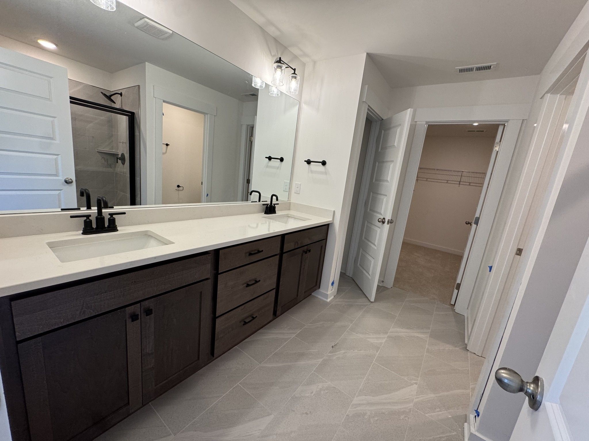 Modern master bathroom featuring double vanity with dark cabinets, white quartz counters, walk-in shower in Davidson Homes The Logan C, Gallatin, Tennessee