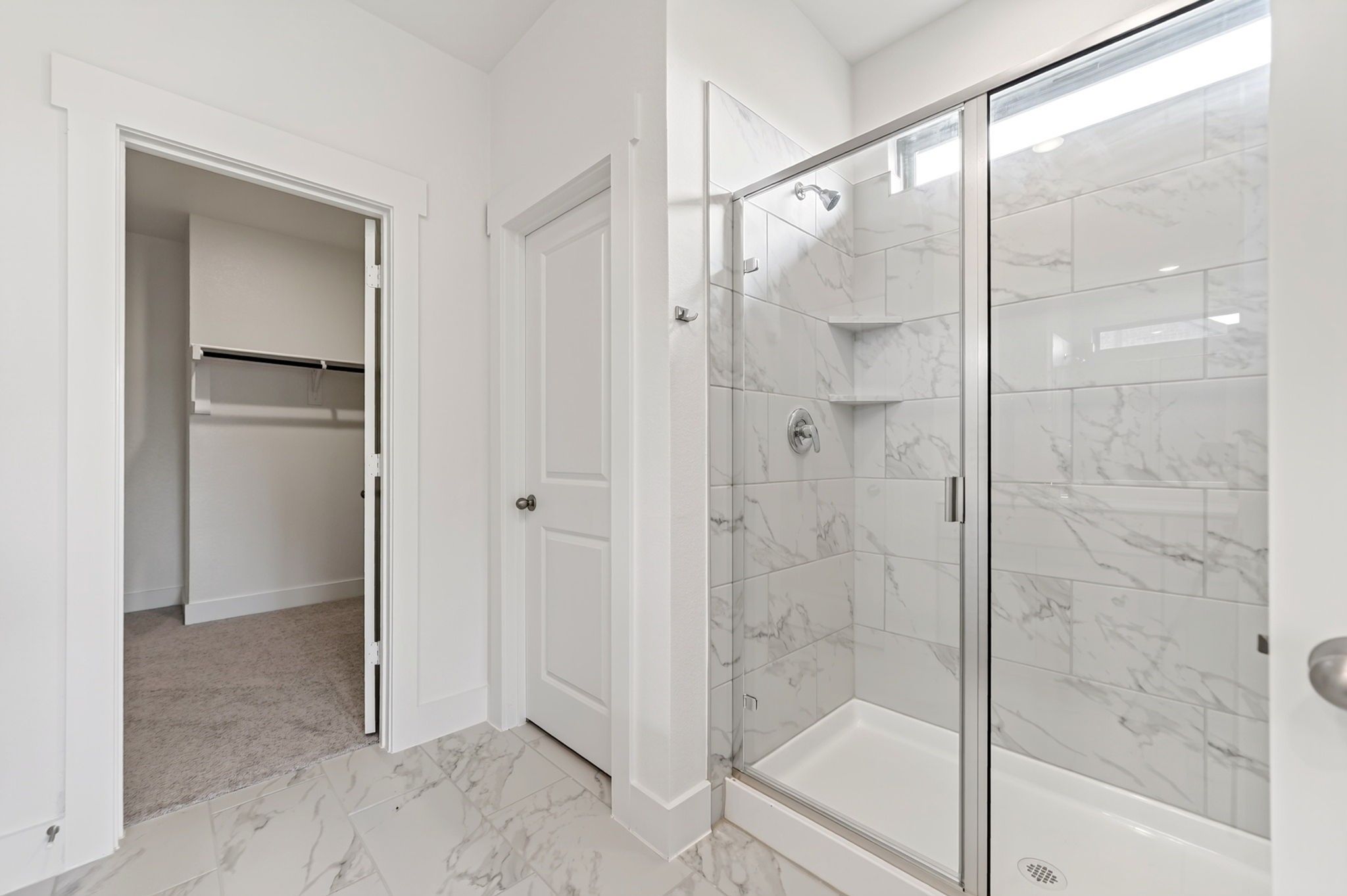 Marble-tiled walk-in shower with glass door in Davidson Homes The Holly F bathroom in Meadow Ridge Estates, Josephine, Texas