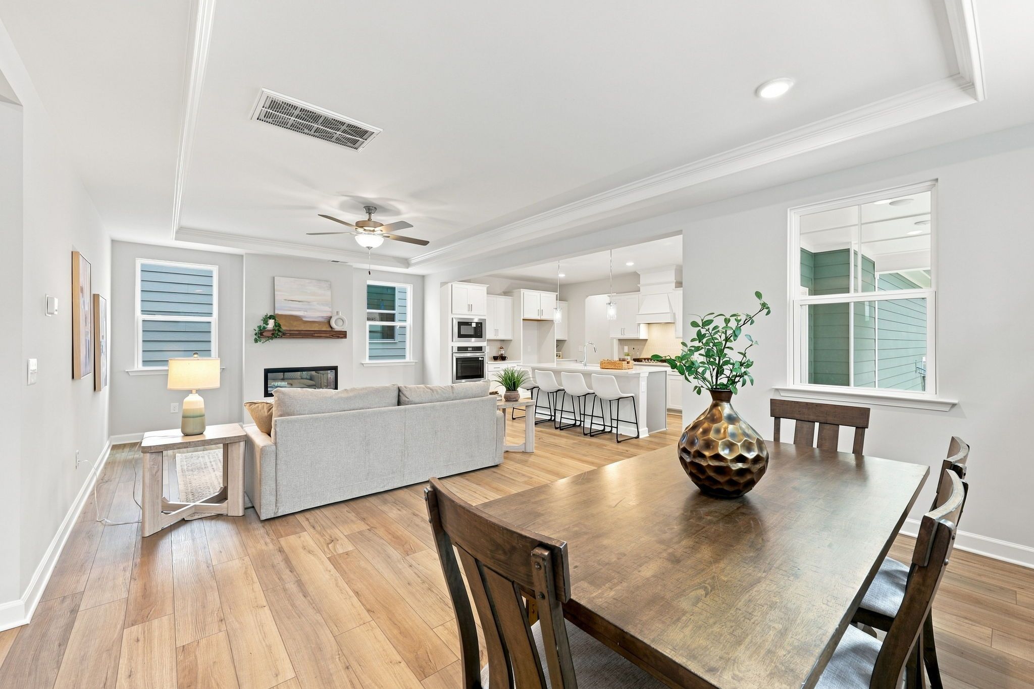 Open-concept living area in The Jordan A featuring a spacious kitchen, modern dining space, and cozy fireplace.