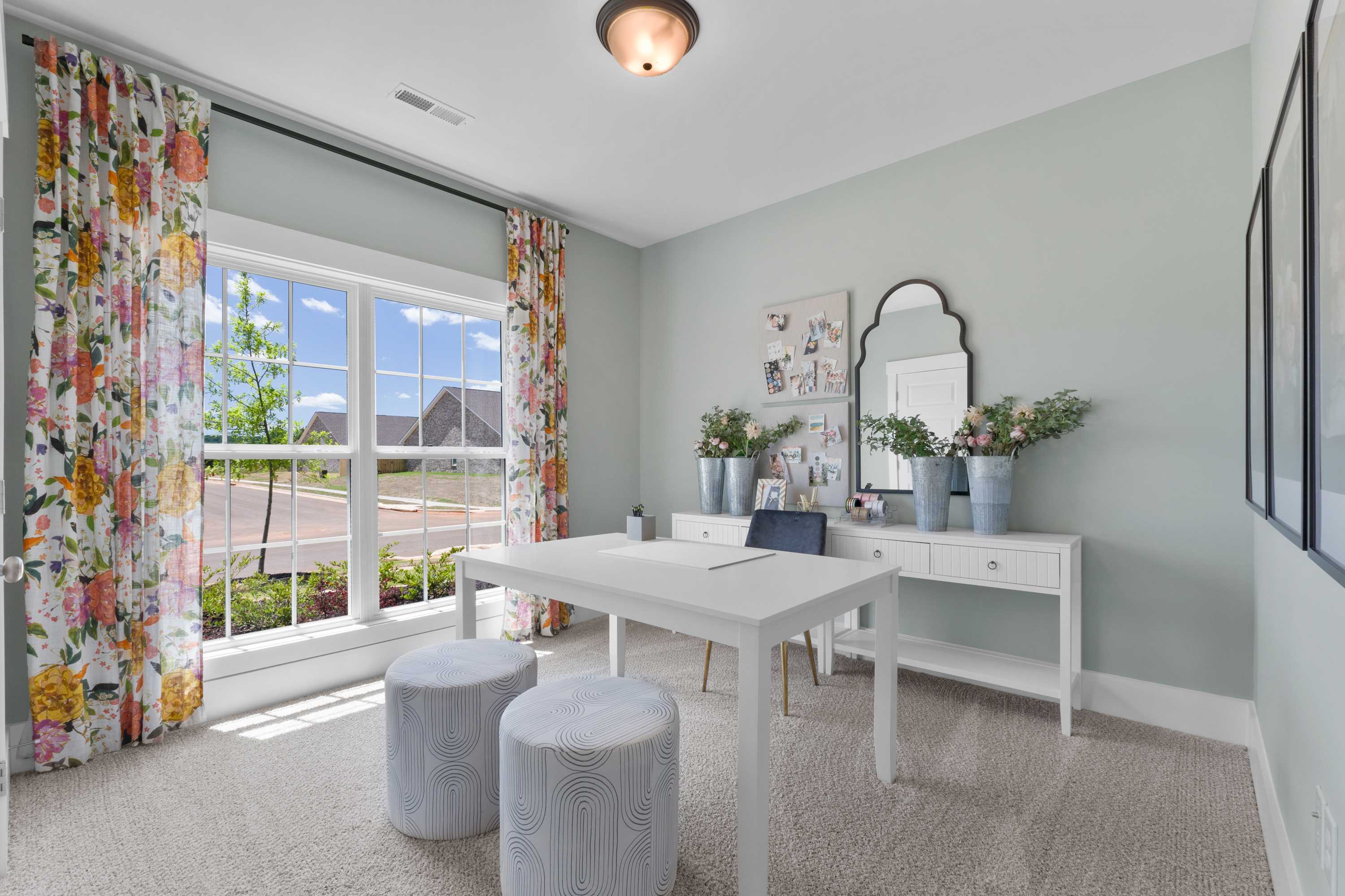 Stylish vanity room at Hollon Meadow in Decatur Alabama with white desk, gold mirror, floral curtains, and sunny window view