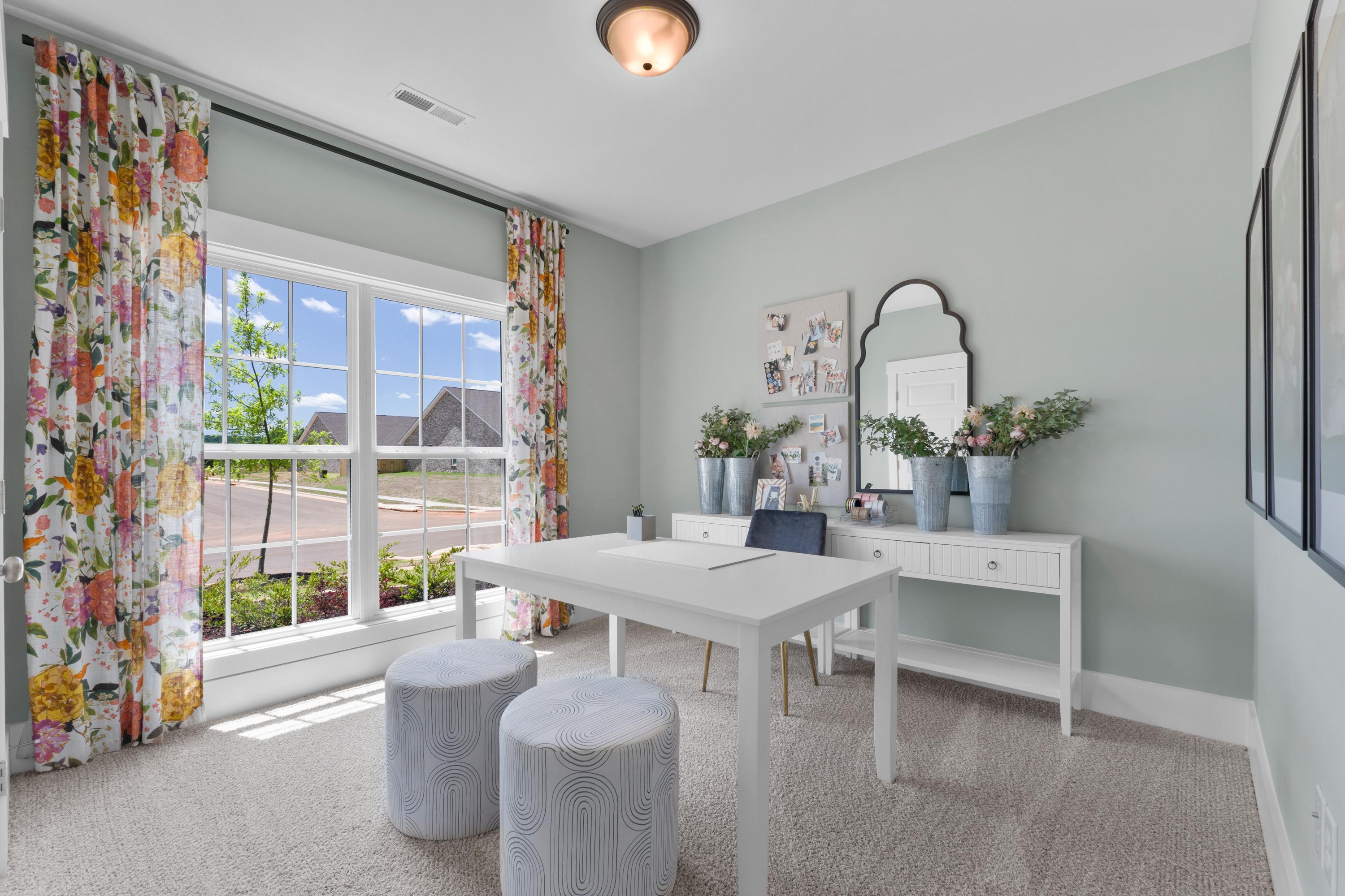 Stylish vanity room at Hollon Meadow in Decatur Alabama with white desk, gold mirror, floral curtains, and sunny window view