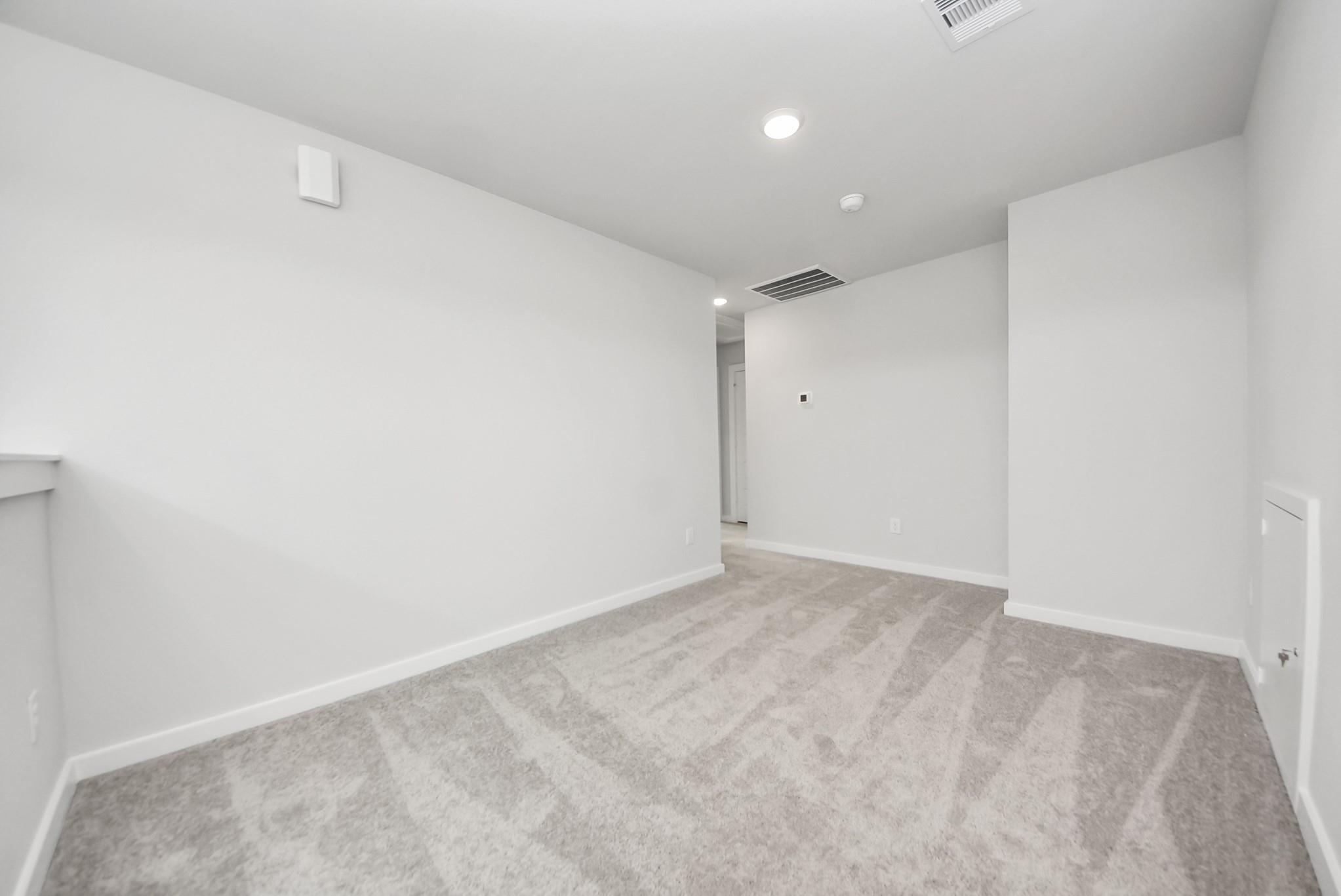 Bright, carpeted flex room or loft in The Blanco E floor plan at The Villages at WestPointe in Dayton, Texas.