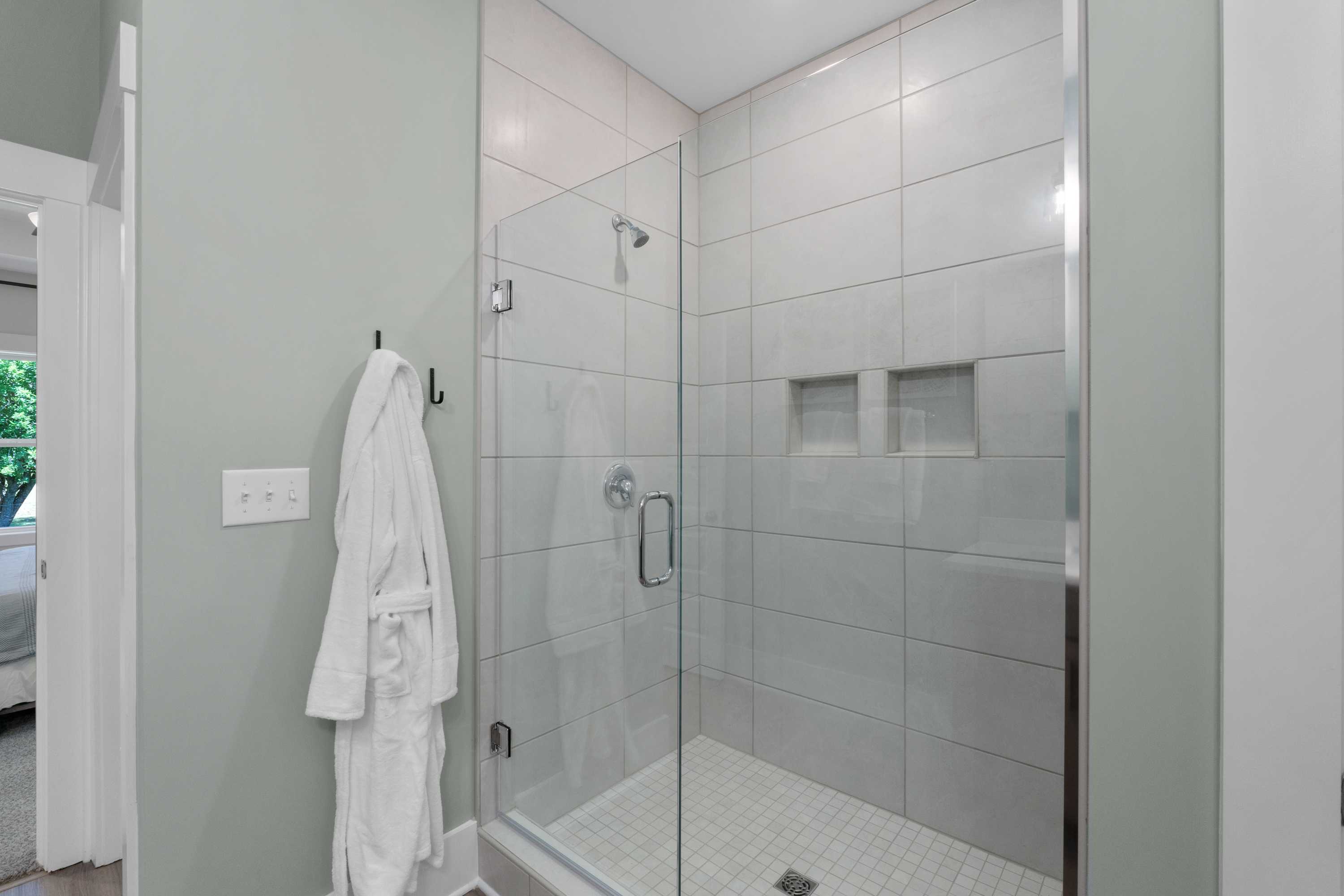 Luxury walk-in shower in Hollon Meadow Decatur AL bathroom by Davidson Homes featuring subway tiles and frameless glass door