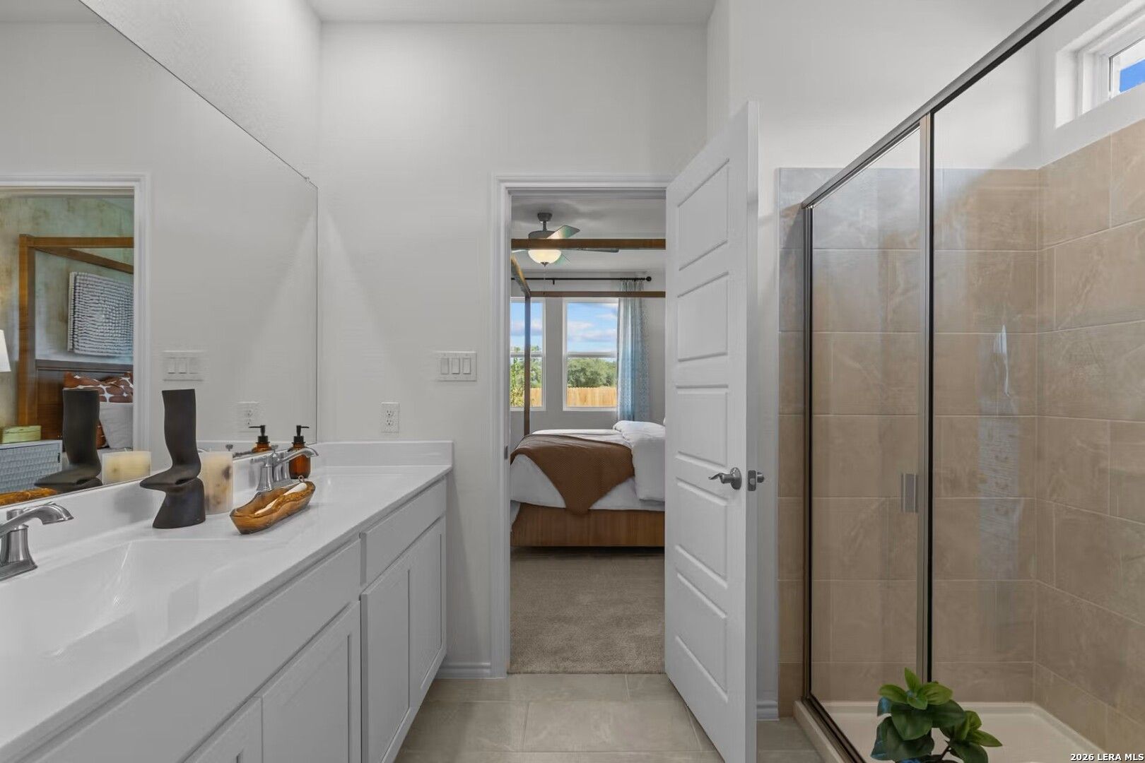 Elegant master bathroom with double vanity, frameless glass shower, and open bedroom view in Davidson Homes The Daphne K, Bricewood, San Antonio