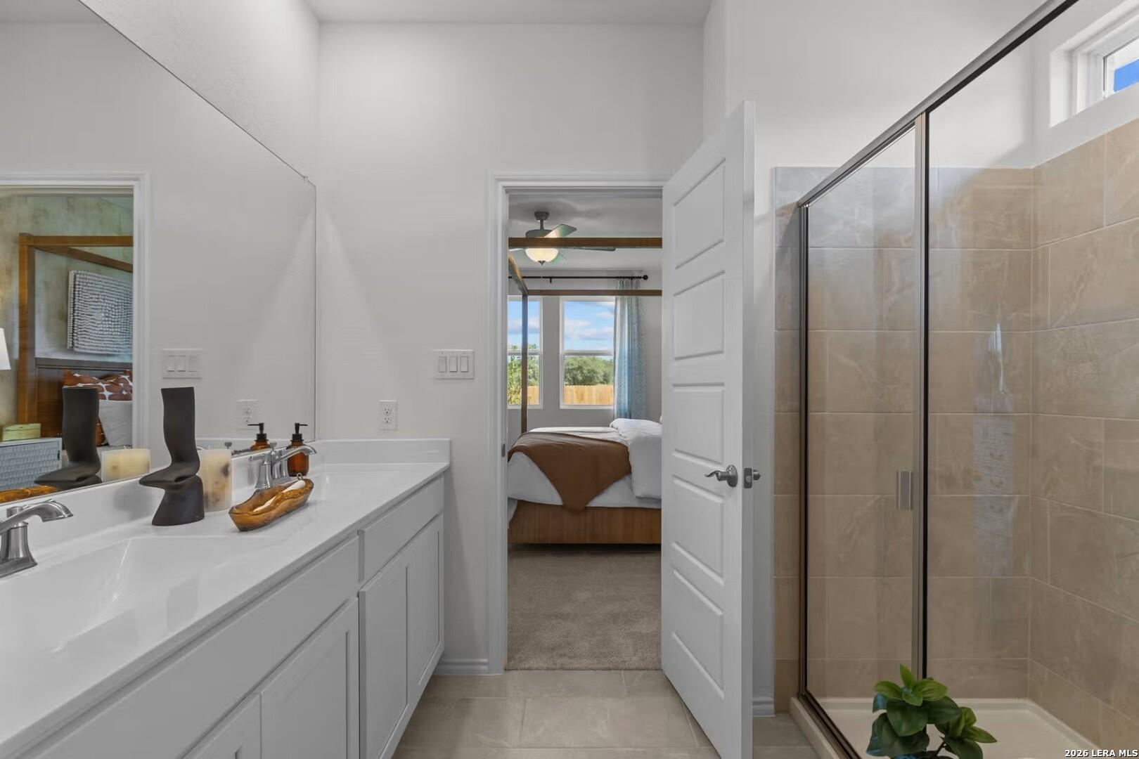 Elegant master bathroom with double vanity, frameless glass shower, and open bedroom view in Davidson Homes The Daphne K, Bricewood, San Antonio