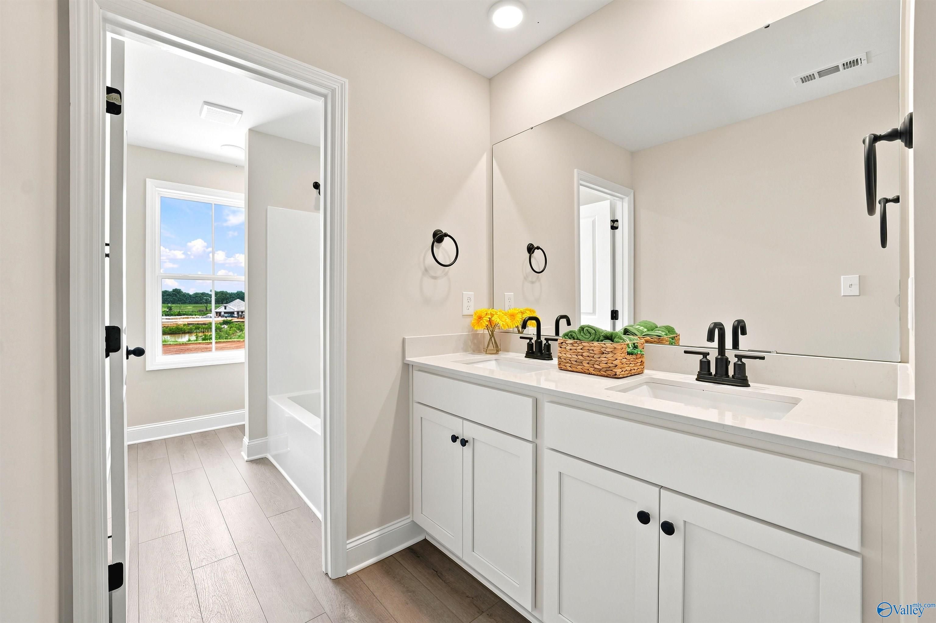 Modern double vanity with matte black faucets in The Burton B floor plan at Heritage Lakes in New Market, Alabama.
