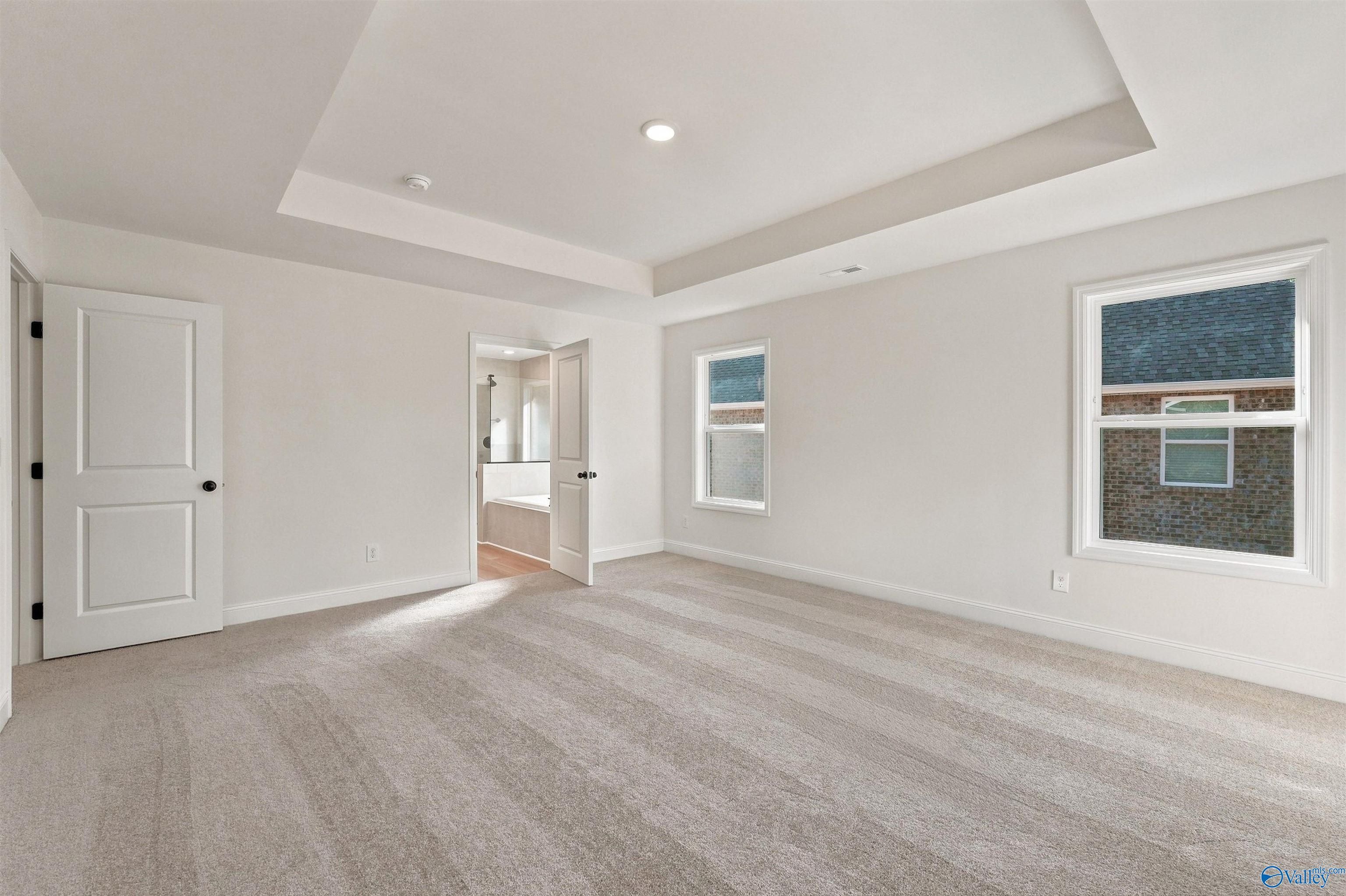 Spacious master bedroom with tray ceiling in The Chelsea C floor plan at Creek Grove in New Market, Alabama.
