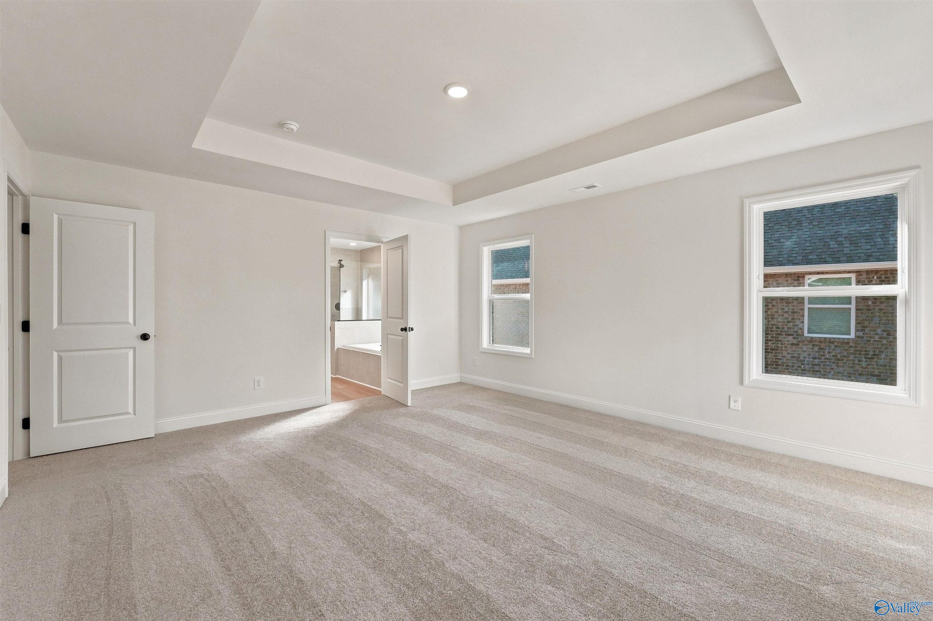Spacious master bedroom with tray ceiling in The Chelsea C floor plan at Creek Grove in New Market, Alabama.