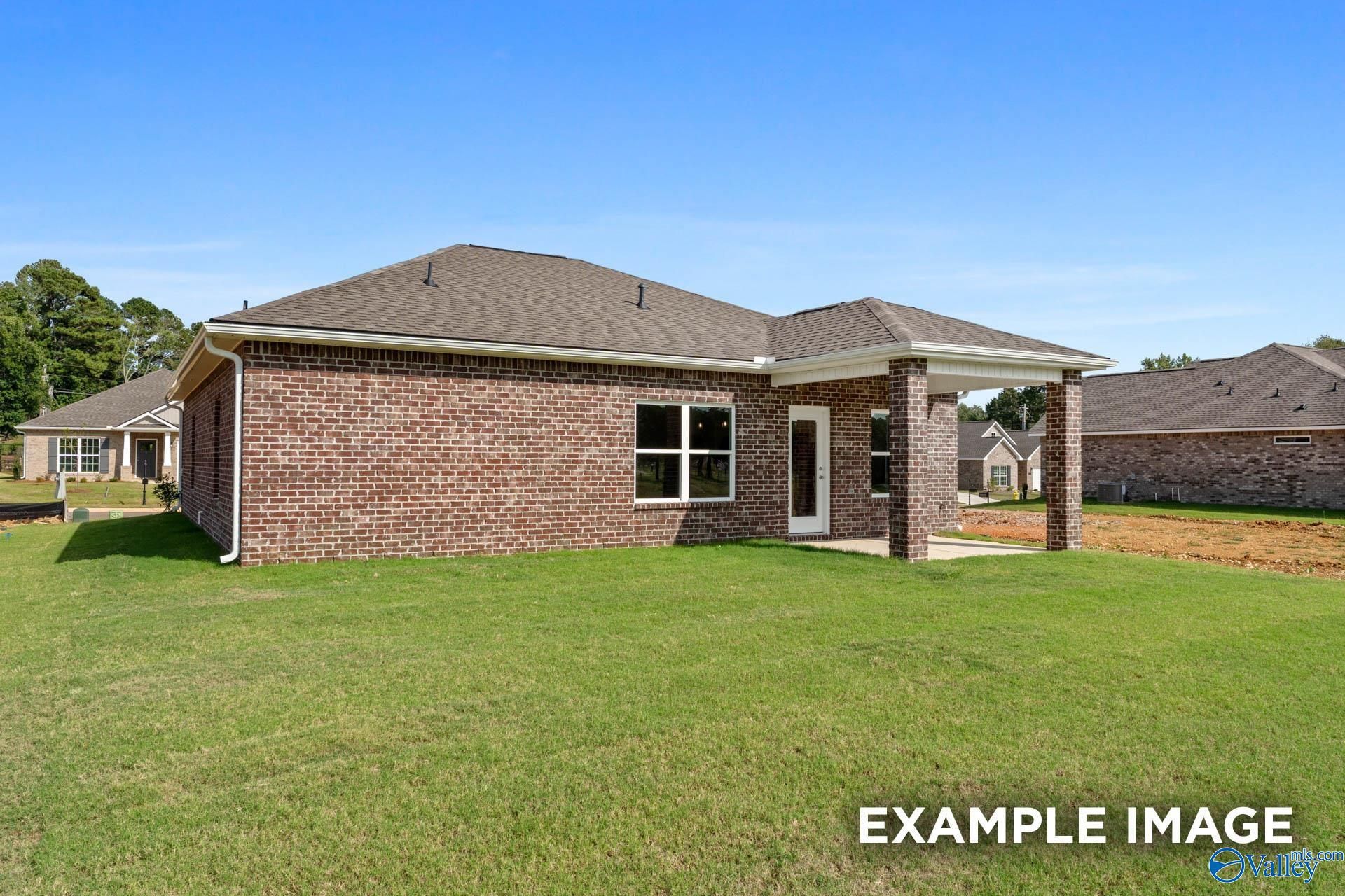 Side view of brick single-story 3-bedroom home with 2-car garage and covered entry in Ramsay Cove, Owens Cross Roads, Alabama