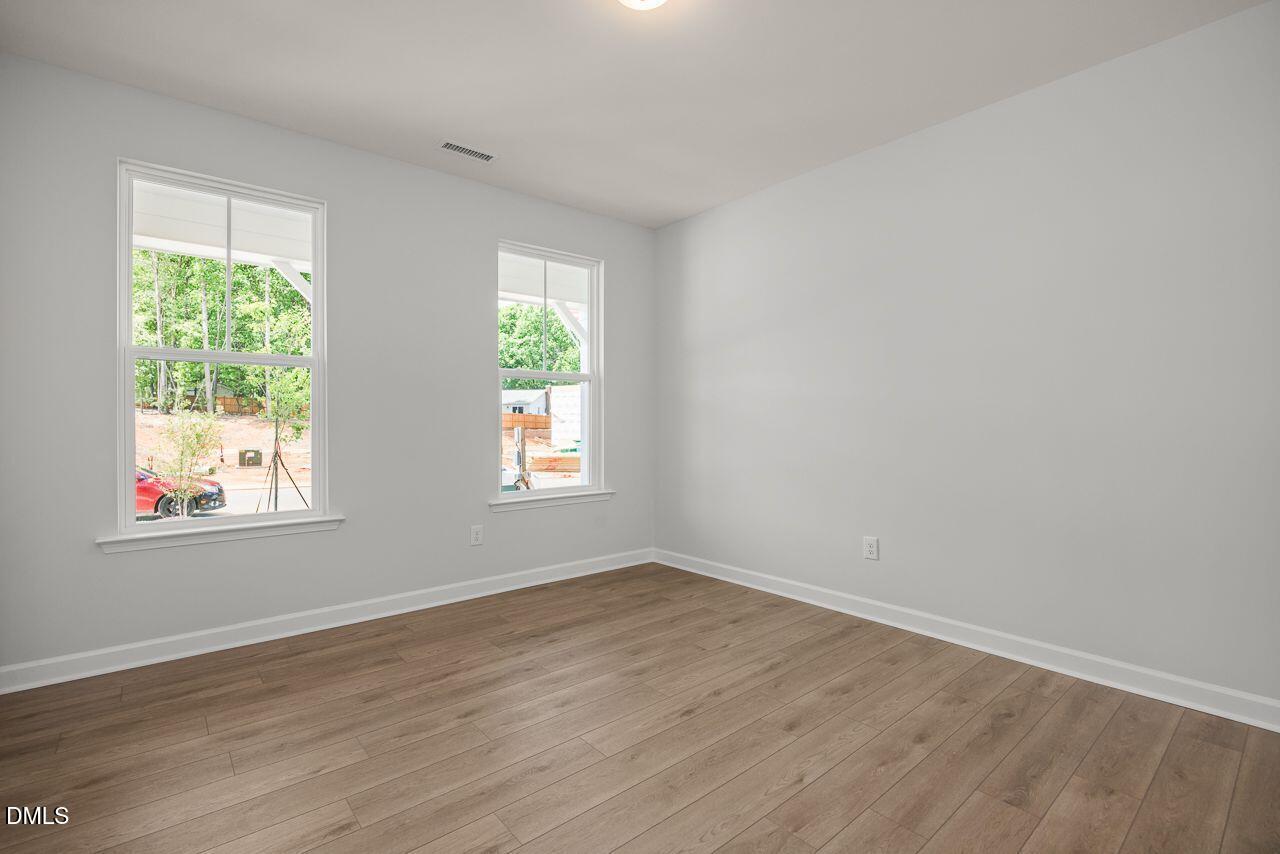 Bright, neutral bedroom with wood-look flooring in The Birch II A floor plan at Montrose in Aberdeen, North Carolina.