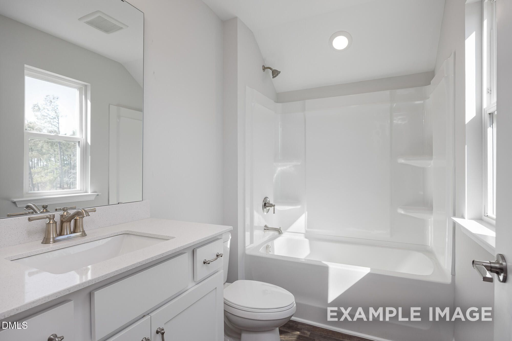 Bright bathroom featuring white vanity, soaking tub, and walk-in shower in 4-bedroom Davidson Homes The Cypress B II, Angier, NC